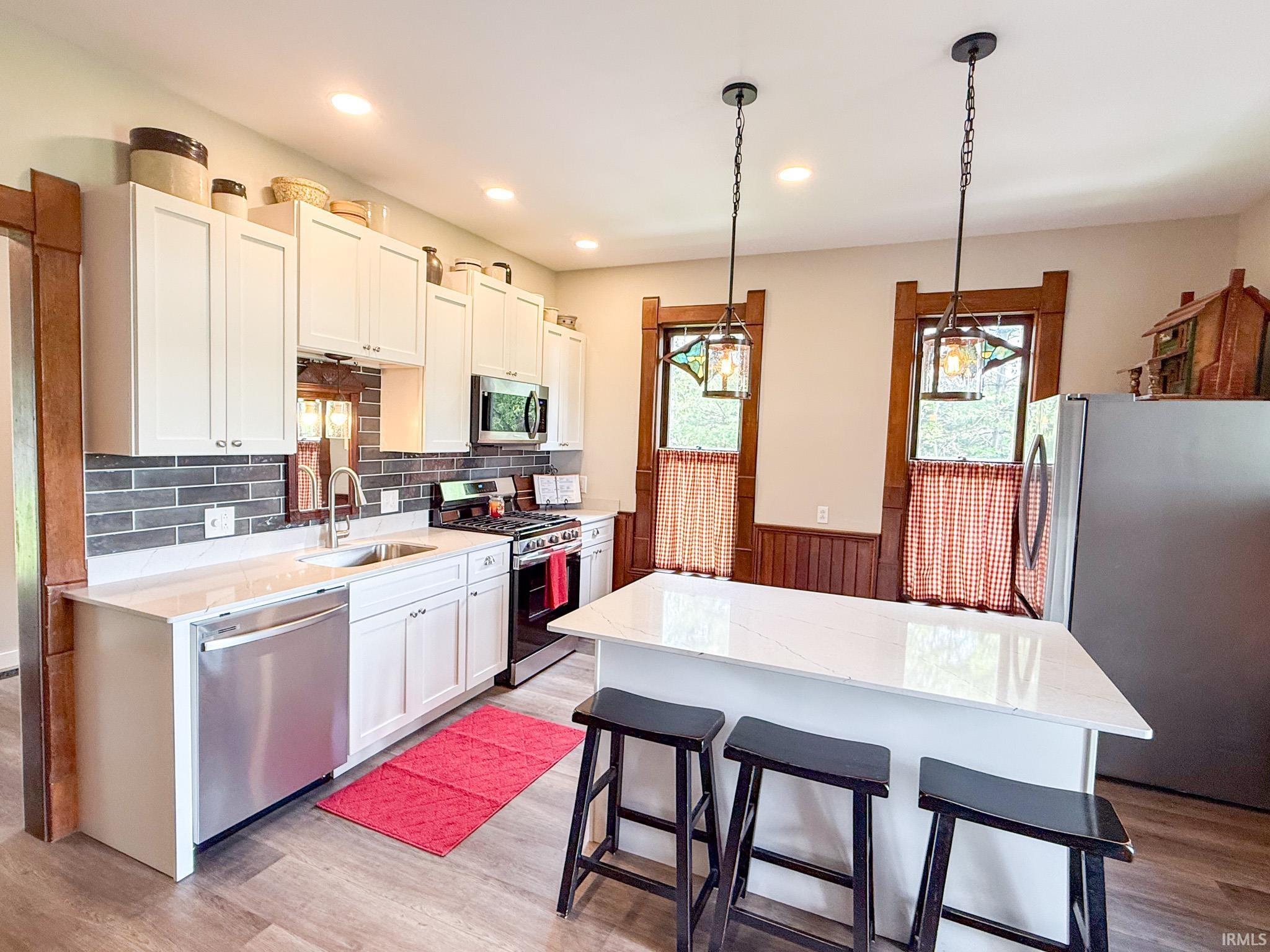 Image 2: Modern kitchen featuring white cabinetry, a stone-finish countertop, and stainless steel appliances, Kitchen Image 2: Modern kitchen featuring white cabinetry, a stone-finish countertop, and stainless steel appliances, Kitchen