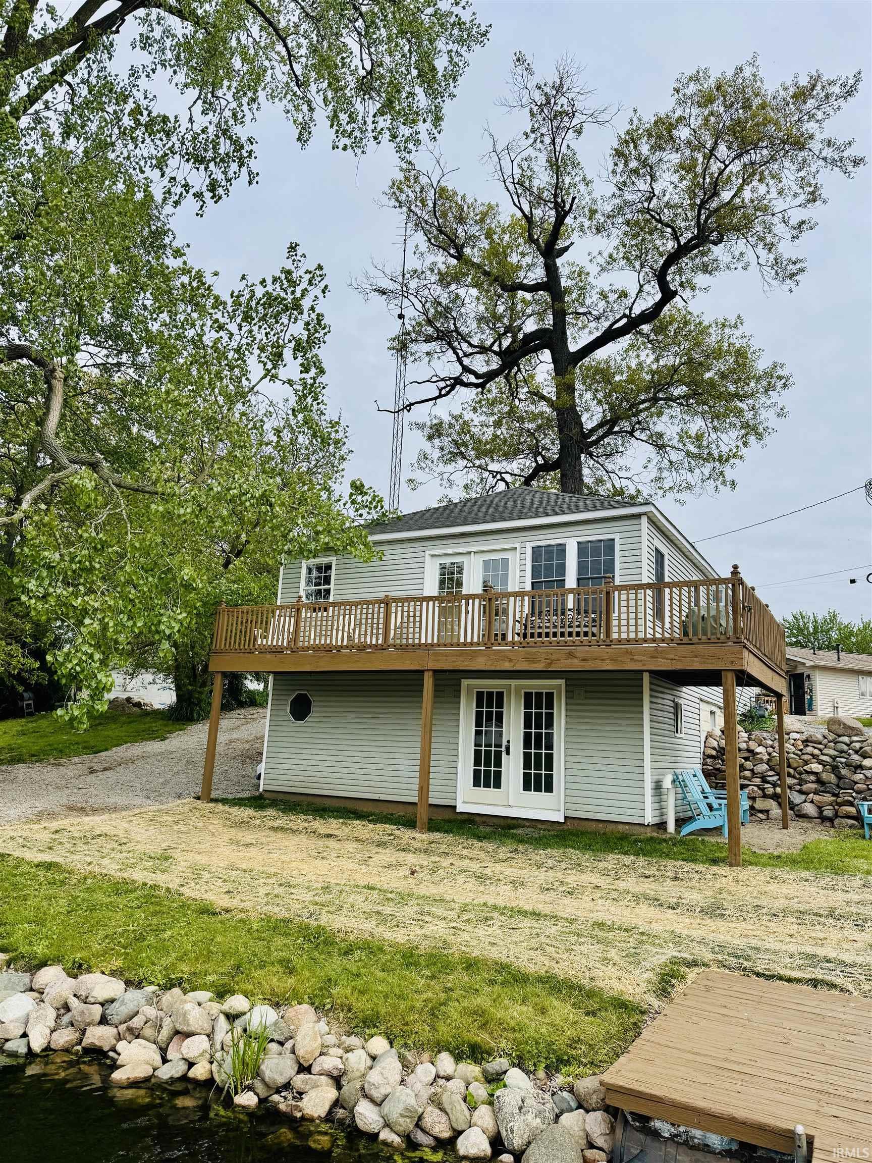 Image 1: Waterfront property featuring a wood dock, rock-lined shore, and a manicured lawn, Back Of Structure Image 1: Waterfront property featuring a wood dock, rock-lined shore, and a manicured lawn, Back Of Structure