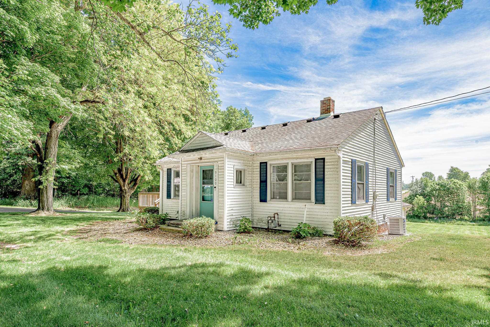 Image 3: White siding exterior featuring contrasting blue shutters, a light teal entry door, and a prominent brick chimney, Front Of Structure Image 3: White siding exterior featuring contrasting blue shutters, a light teal entry door, and a prominent brick chimney, Front Of Structure
