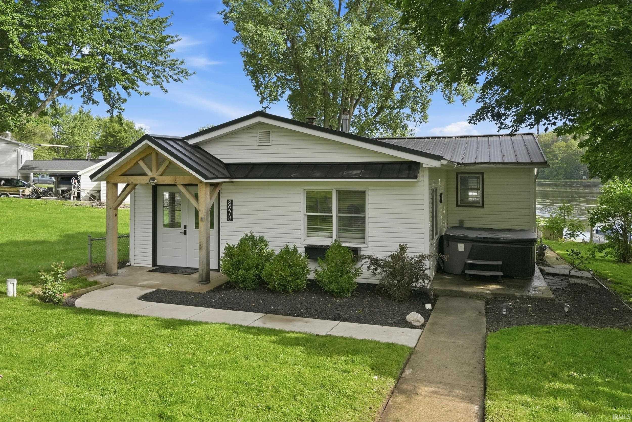 Image 0: White siding exterior with a dark metal roof, Front Of Structure Image 0: White siding exterior with a dark metal roof, Front Of Structure