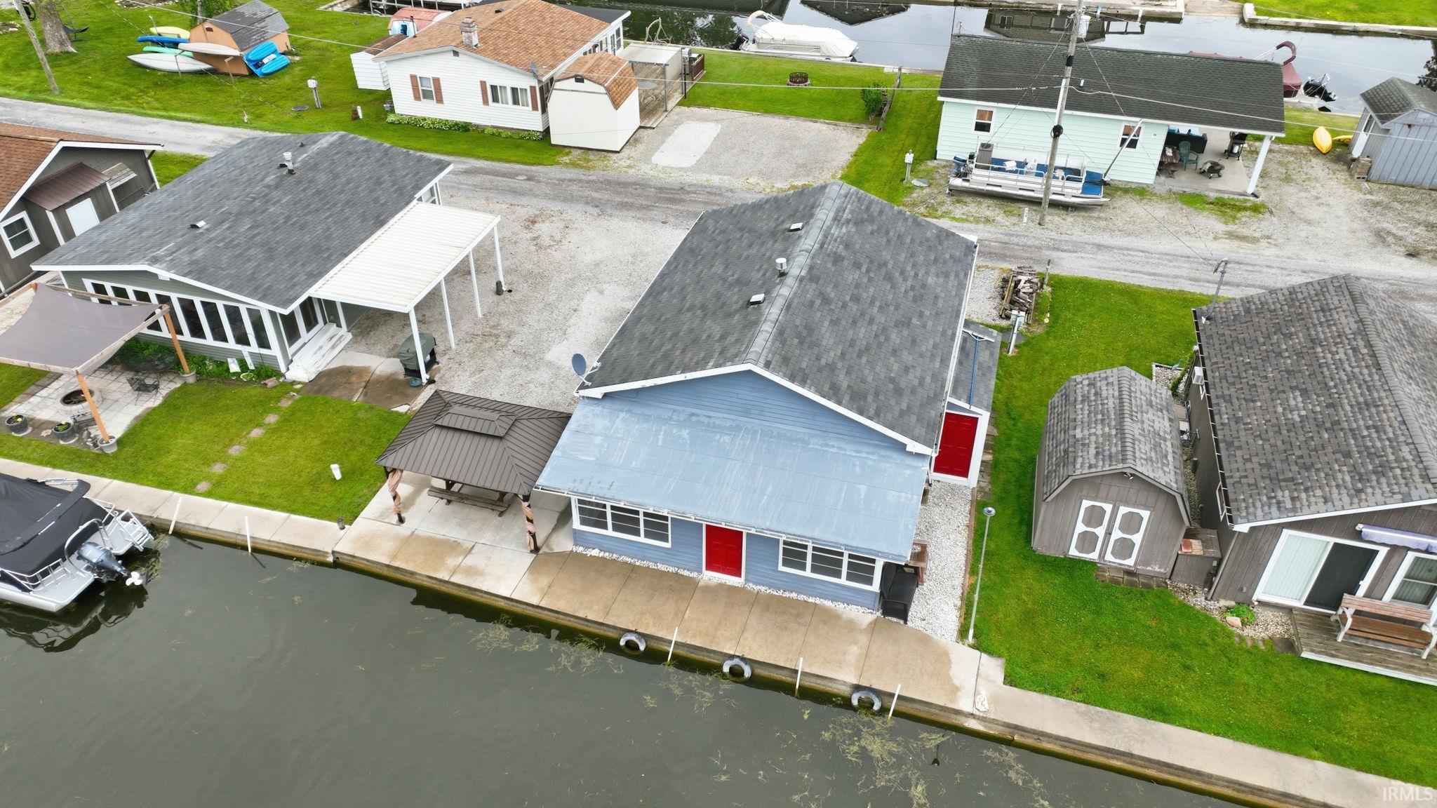 Image 2: Waterfront property featuring a concrete seawall, a covered patio, and a dedicated boat slip, Aerial View