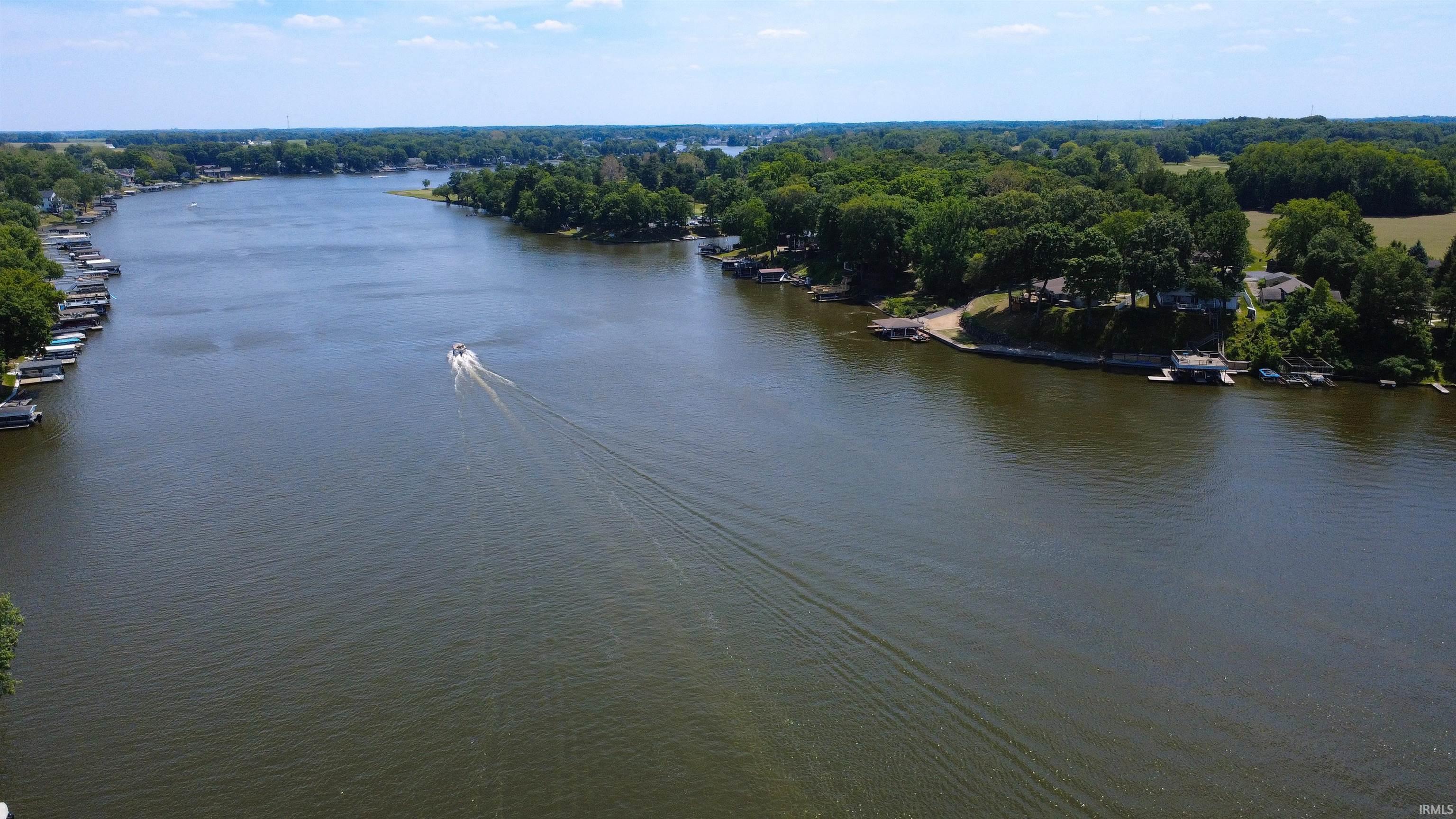 Image 1: Expansive waterfront property featuring a wide river, lush tree lines, and multiple private boat docks, View Image 1: Expansive waterfront property featuring a wide river, lush tree lines, and multiple private boat docks, View