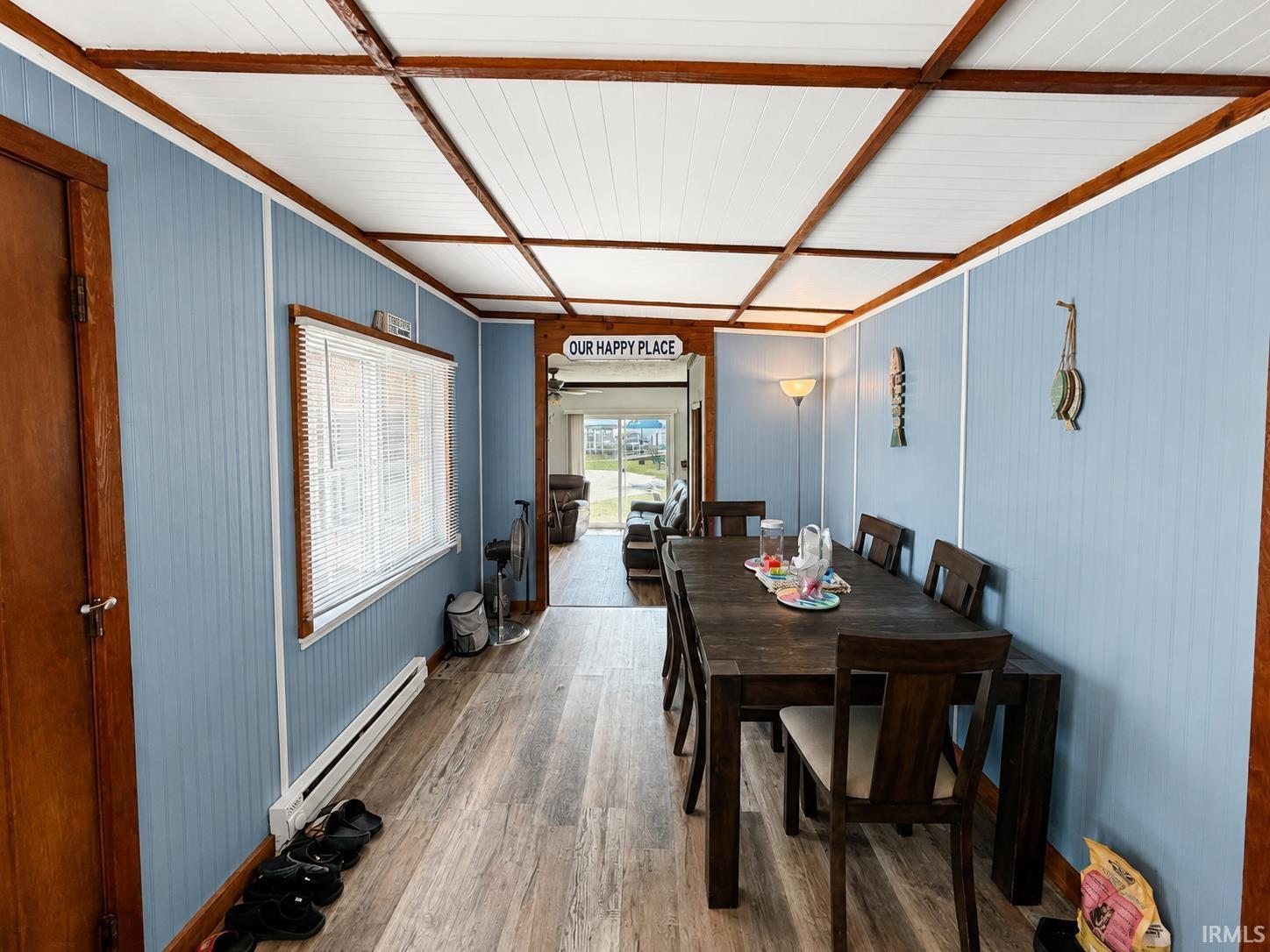 Image 3: Dining area featuring wood-finish flooring, light blue vertical plank paneling, and a white beadboard ceiling with exposed wood beams, Dining Area Image 3: Dining area featuring wood-finish flooring, light blue vertical plank paneling, and a white beadboard ceiling with exposed wood beams, Dining Area