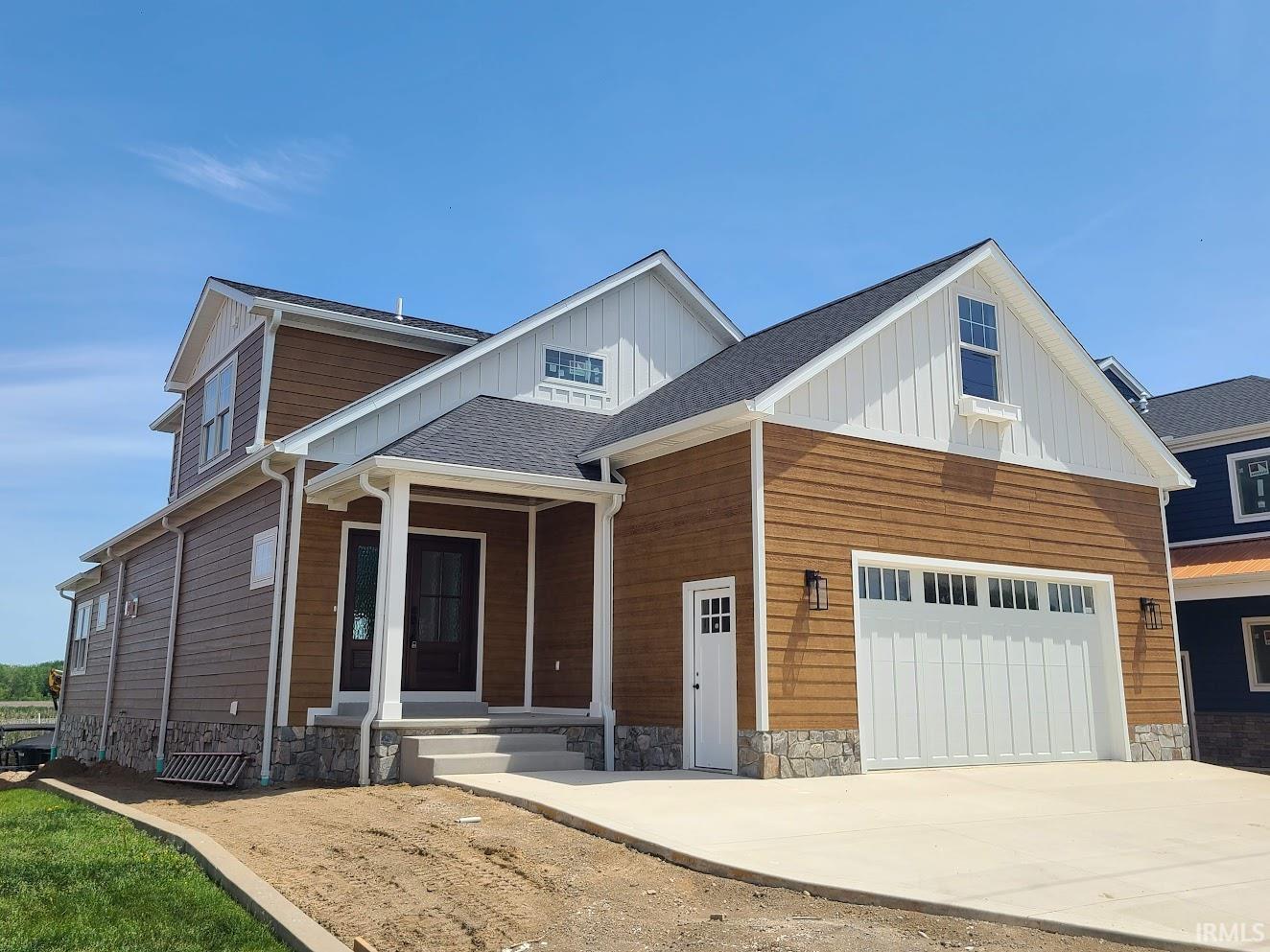 Image 0: Two-story residence featuring a covered entry porch, dark wood-finish entry door, and a two-car garage with a white panel door, Front Of Structure Image 0: Two-story residence featuring a covered entry porch, dark wood-finish entry door, and a two-car garage with a white panel door, Front Of Structure