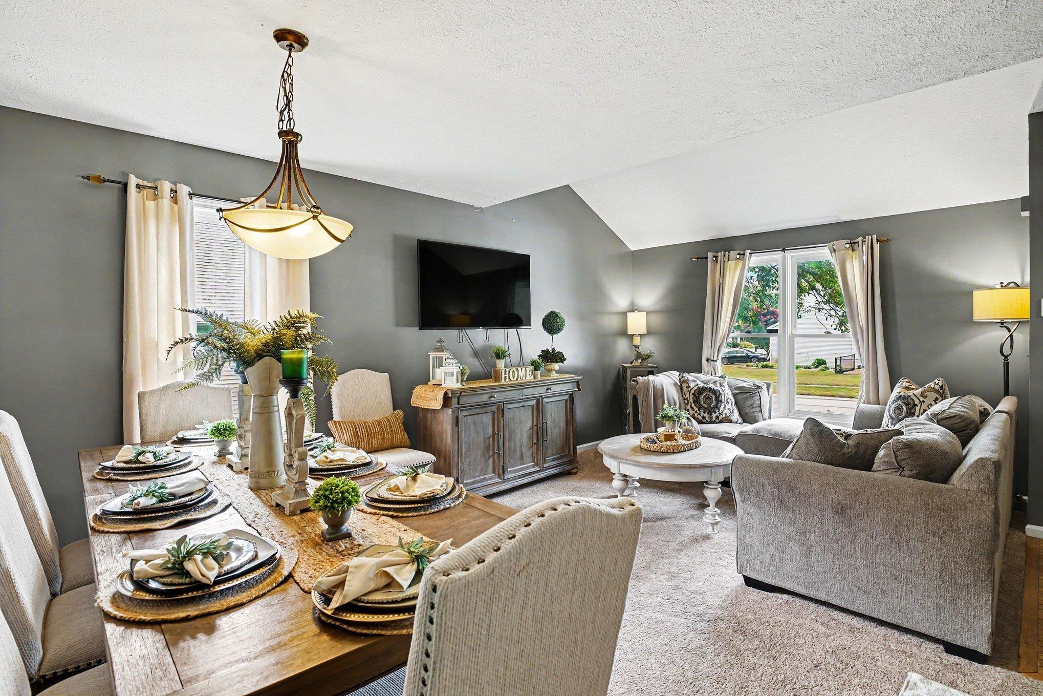 Image 3: Dining area with a wood-finish table, upholstered chairs, and a chandelier, featuring vaulted ceilings and neutral wall tones, Dining Area