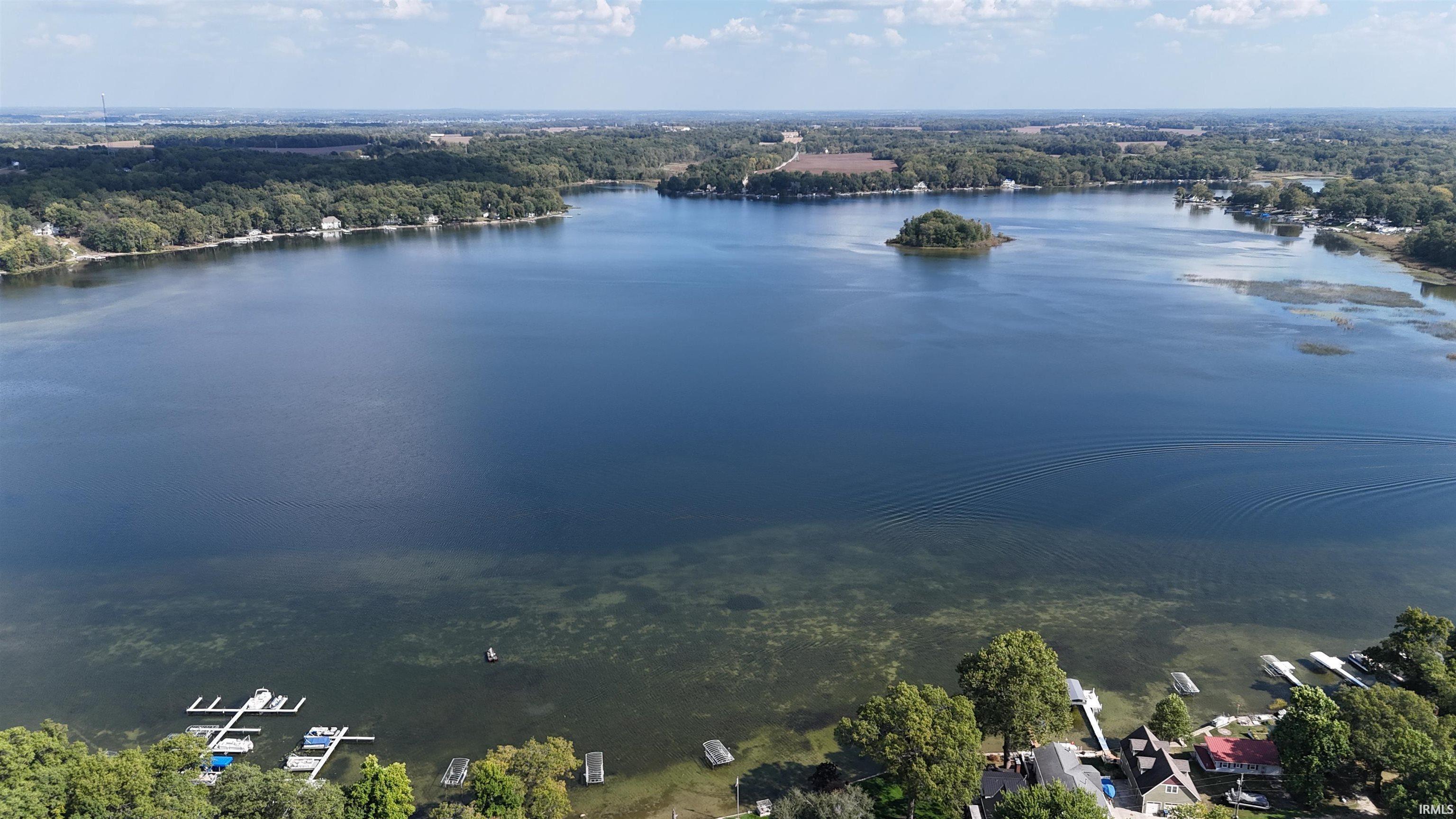 Image 3: Expansive lakefront setting featuring private docks and surrounding mature trees, Aerial View Image 3: Expansive lakefront setting featuring private docks and surrounding mature trees, Aerial View