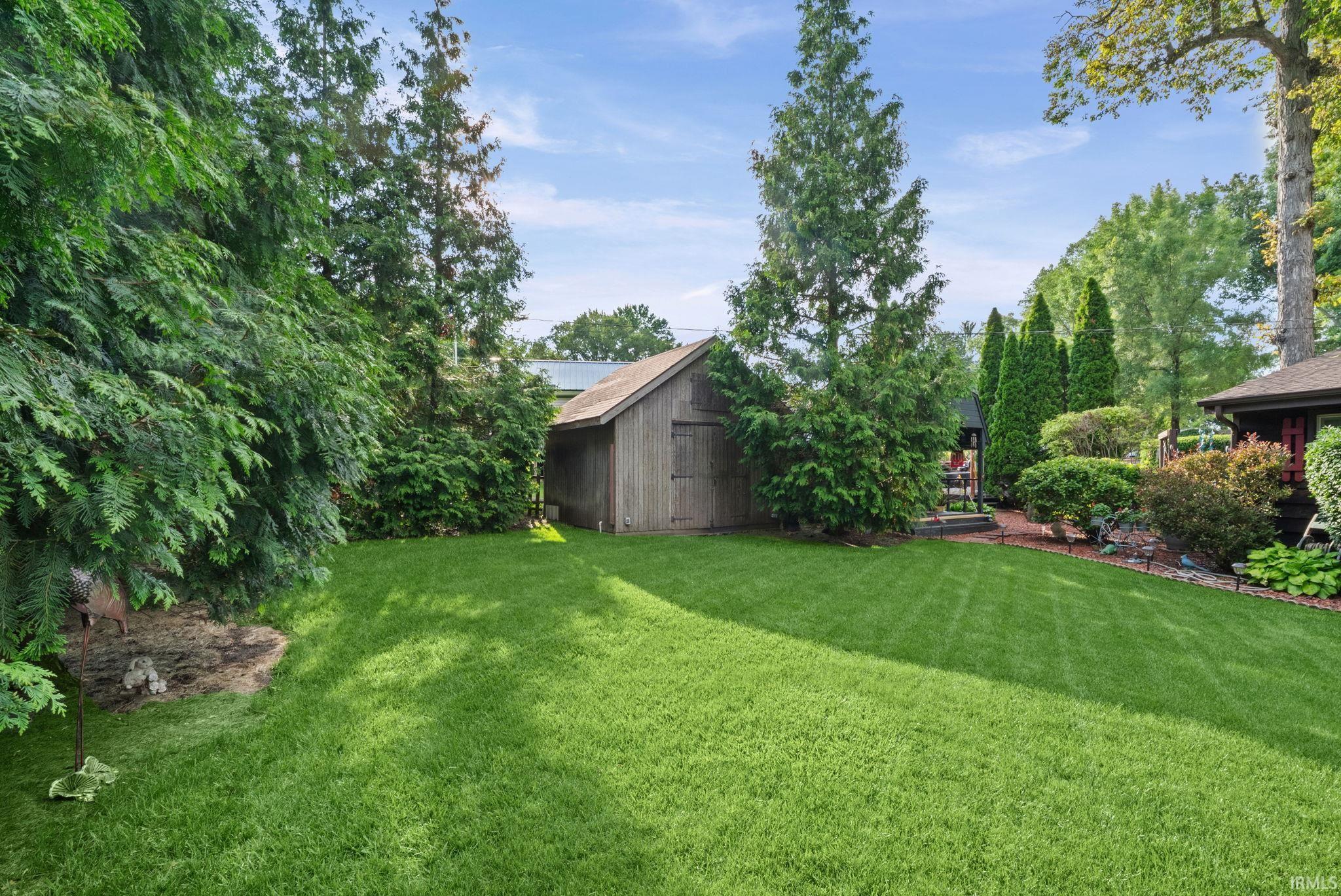 Image 3: Expansive green lawn with mature trees and established landscaping, Yard