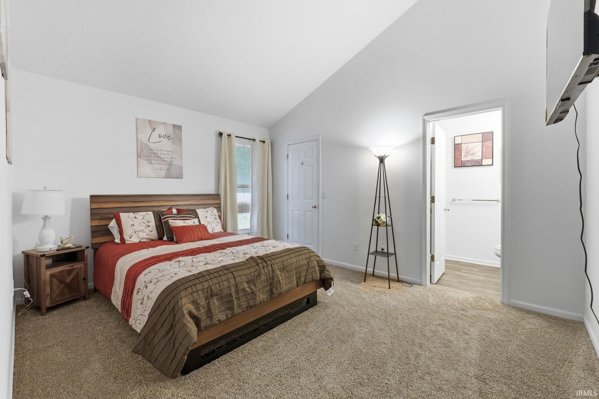 Image 3: Vaulted ceiling, carpet flooring, window with curtains, white painted walls, and an interior door, Bedroom Image 3: Vaulted ceiling, carpet flooring, window with curtains, white painted walls, and an interior door, Bedroom