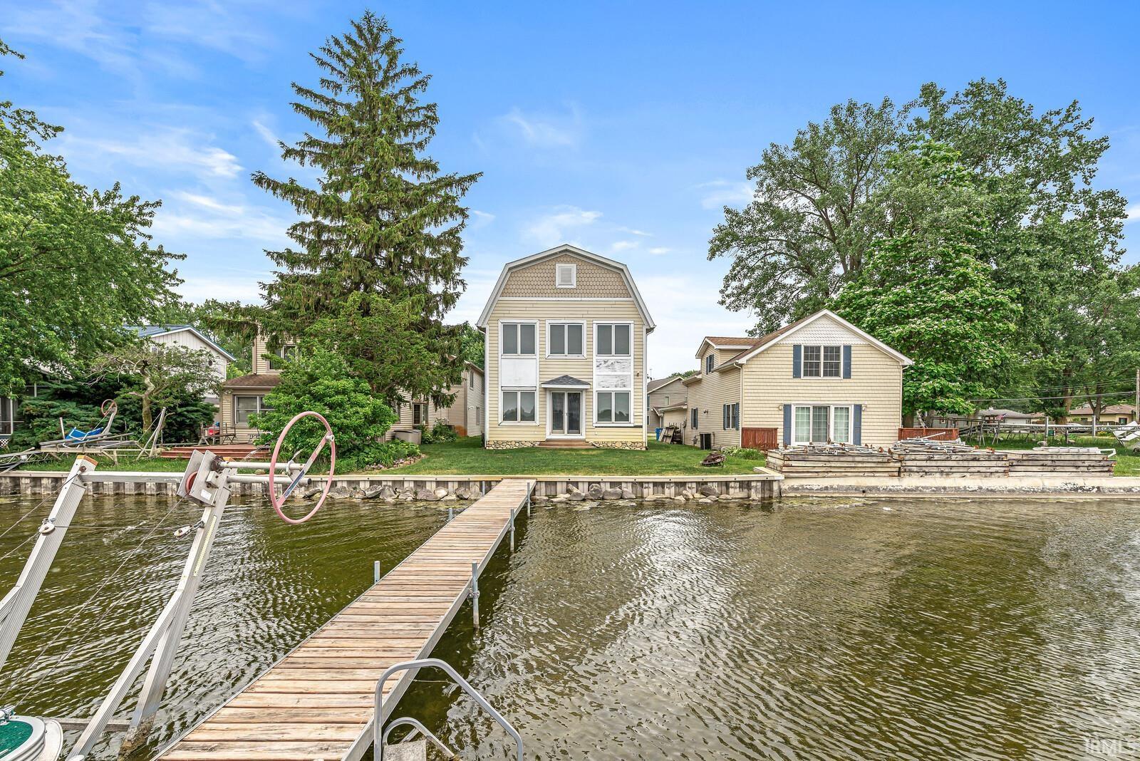 Image 2: Waterfront property featuring a private dock and boat hoist, Back Of Structure