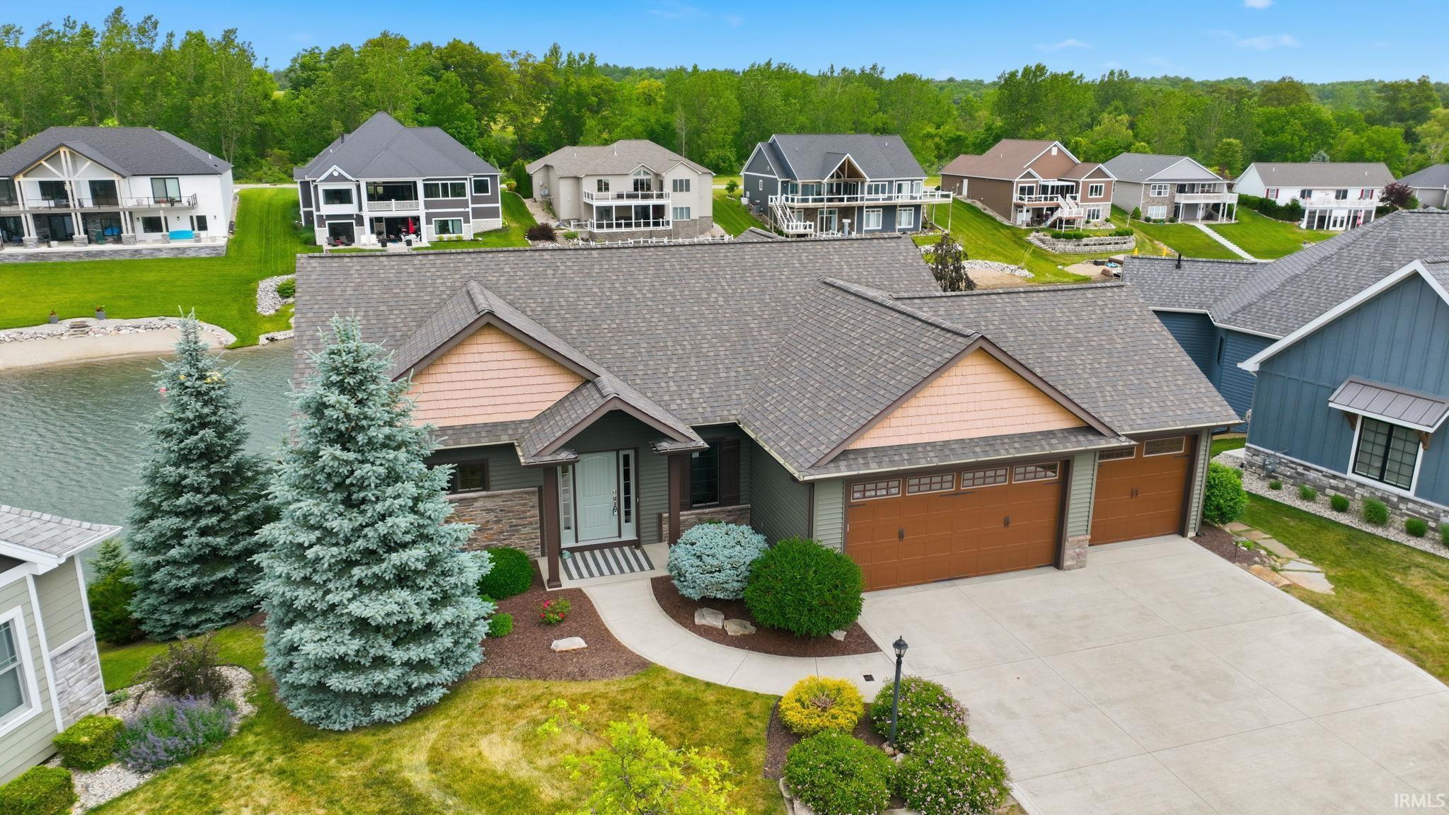 Image 0: Ranch-style residence featuring a prominent front entrance, an attached two-car garage with wood-finish doors, and a concrete driveway, Front Of Structure Image 0: Ranch-style residence featuring a prominent front entrance, an attached two-car garage with wood-finish doors, and a concrete driveway, Front Of Structure