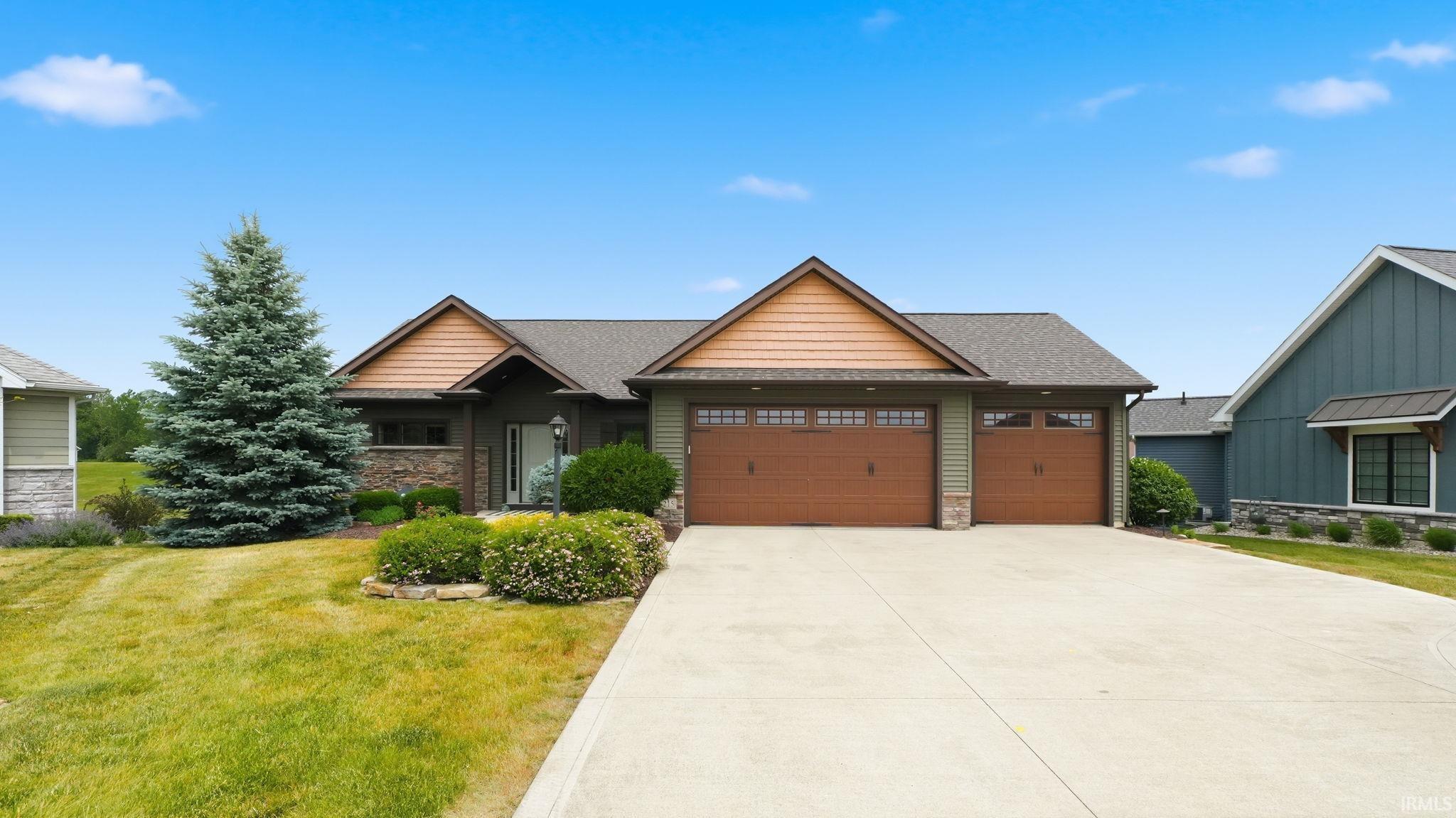Image 1: Craftsman-style exterior featuring a multi-gable roofline, natural stone accents, two attached garages with wood-finish doors, and a concrete driveway, Front Of Structure Image 1: Craftsman-style exterior featuring a multi-gable roofline, natural stone accents, two attached garages with wood-finish doors, and a concrete driveway, Front Of Structure