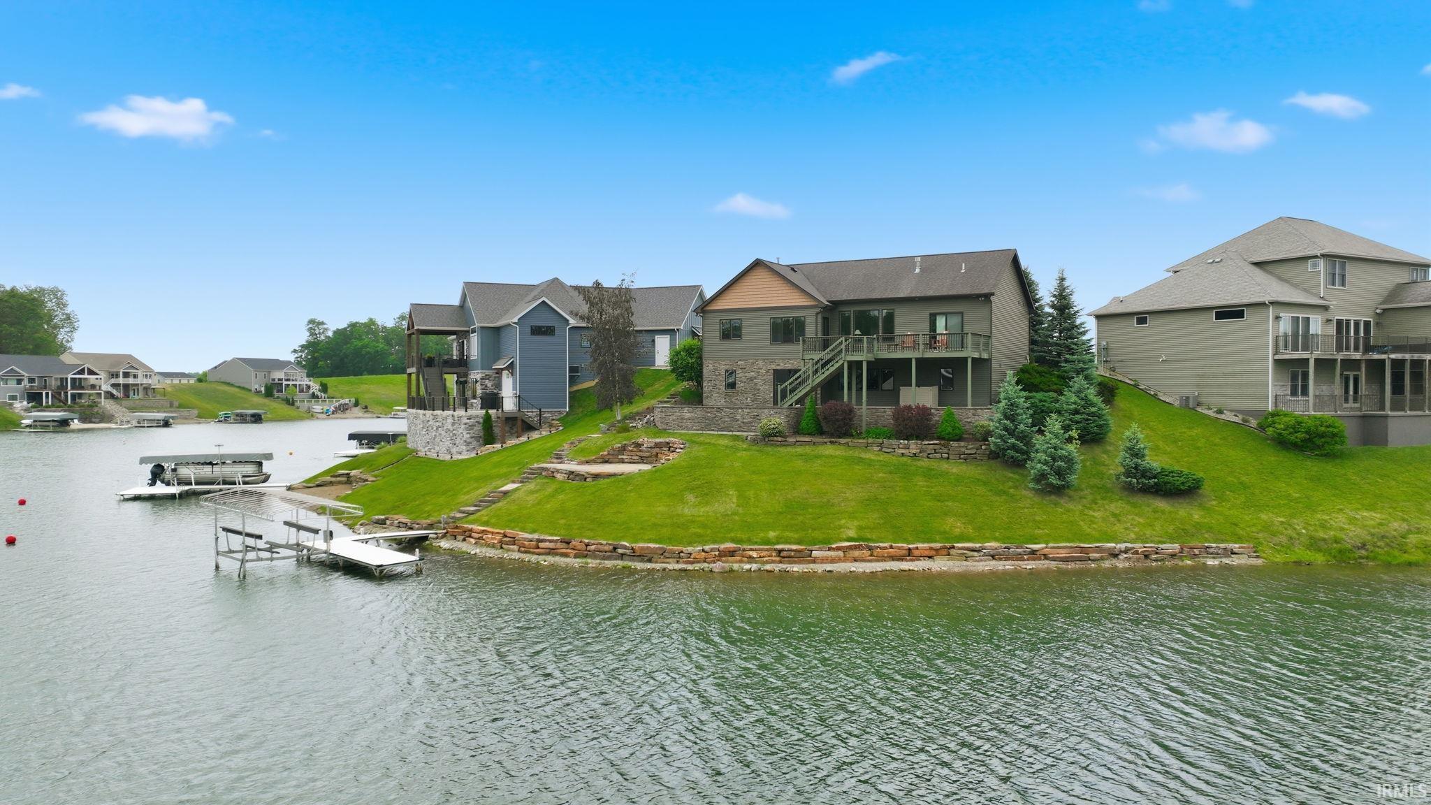 Image 2: Waterside property featuring a multi-level structure with stone and siding exterior, Back Of Structure Image 2: Waterside property featuring a multi-level structure with stone and siding exterior, Back Of Structure