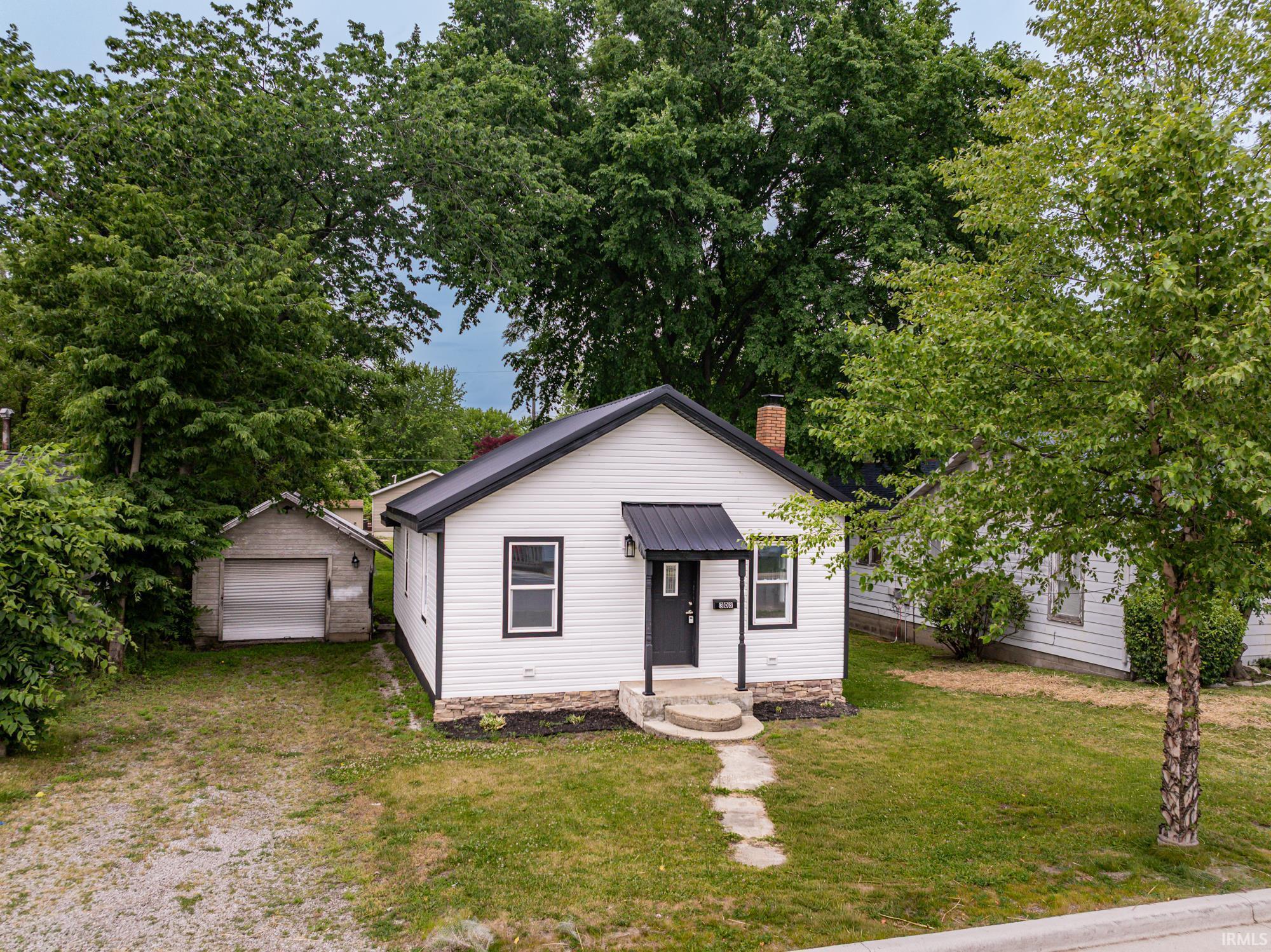 Image 1: White siding exterior with a black metal roof and a matching entry awning, Front Of Structure Image 1: White siding exterior with a black metal roof and a matching entry awning, Front Of Structure