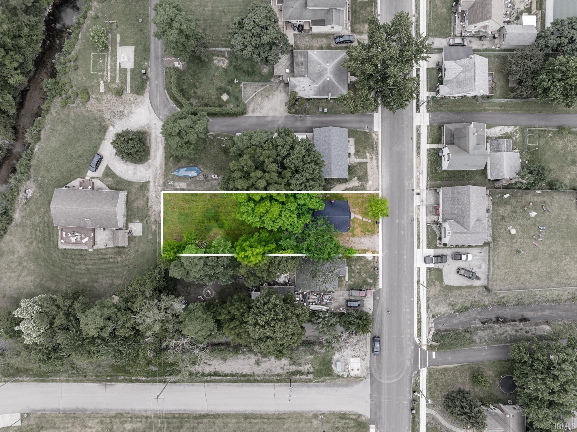 Image 2: Aerial overview of a rectangular lot, outlined in white, featuring a combination of mature trees and open green space, Aerial View Image 2: Aerial overview of a rectangular lot, outlined in white, featuring a combination of mature trees and open green space, Aerial View