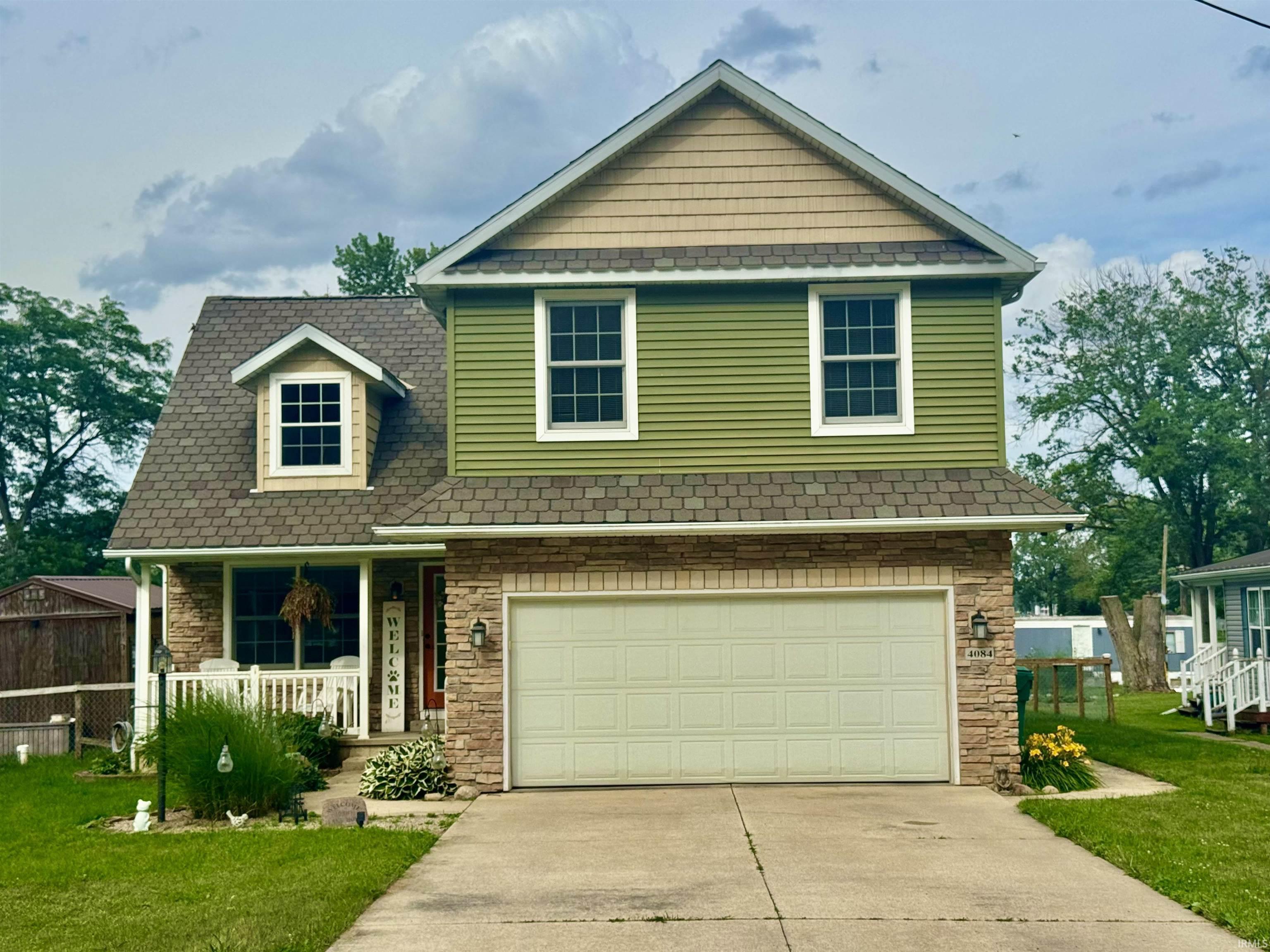Image 0: Two-story residence featuring a combination of stone veneer and horizontal siding, Front Of Structure