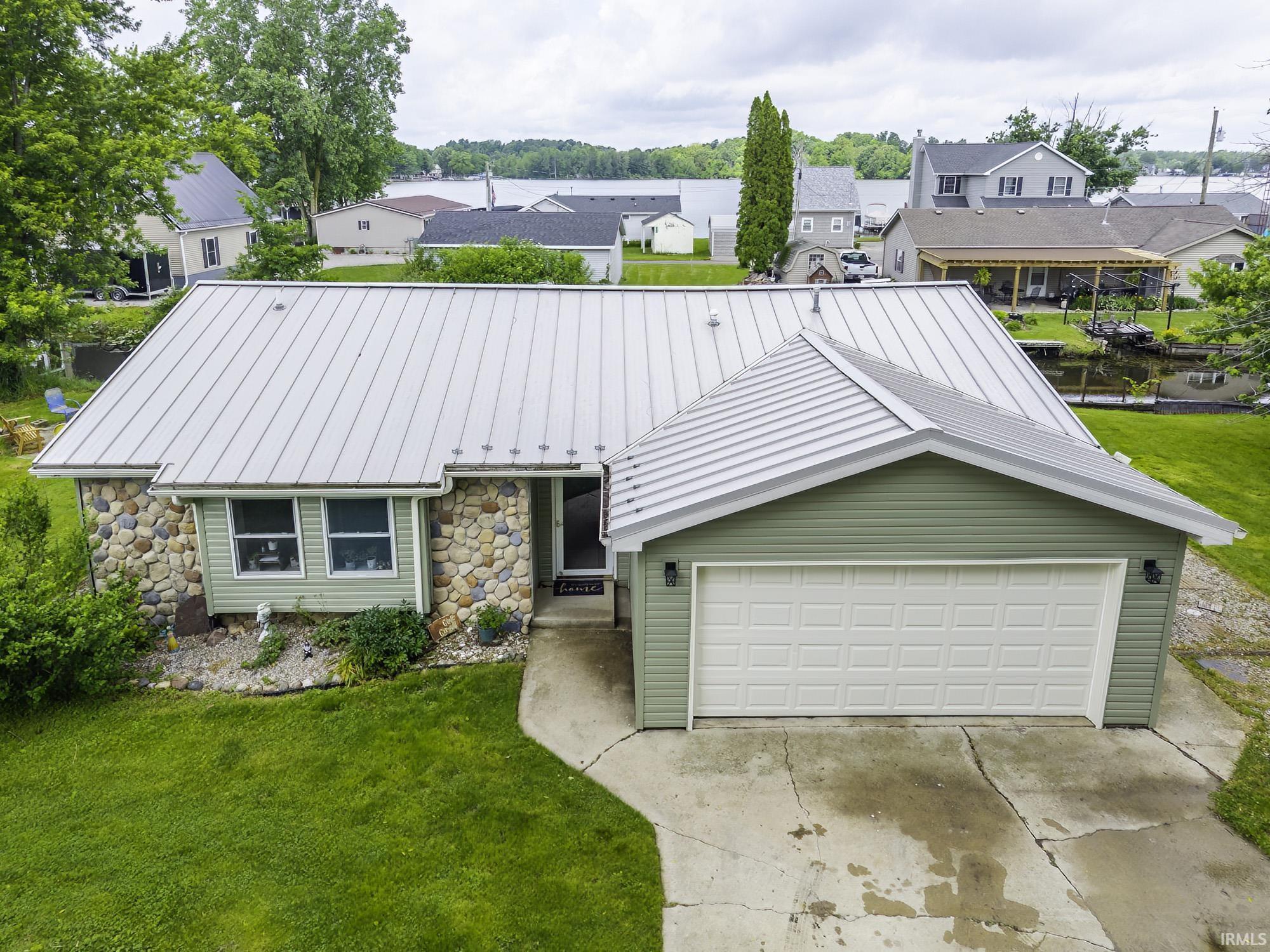 Image 0: Stone and siding exterior with a metal roof, Front Of Structure