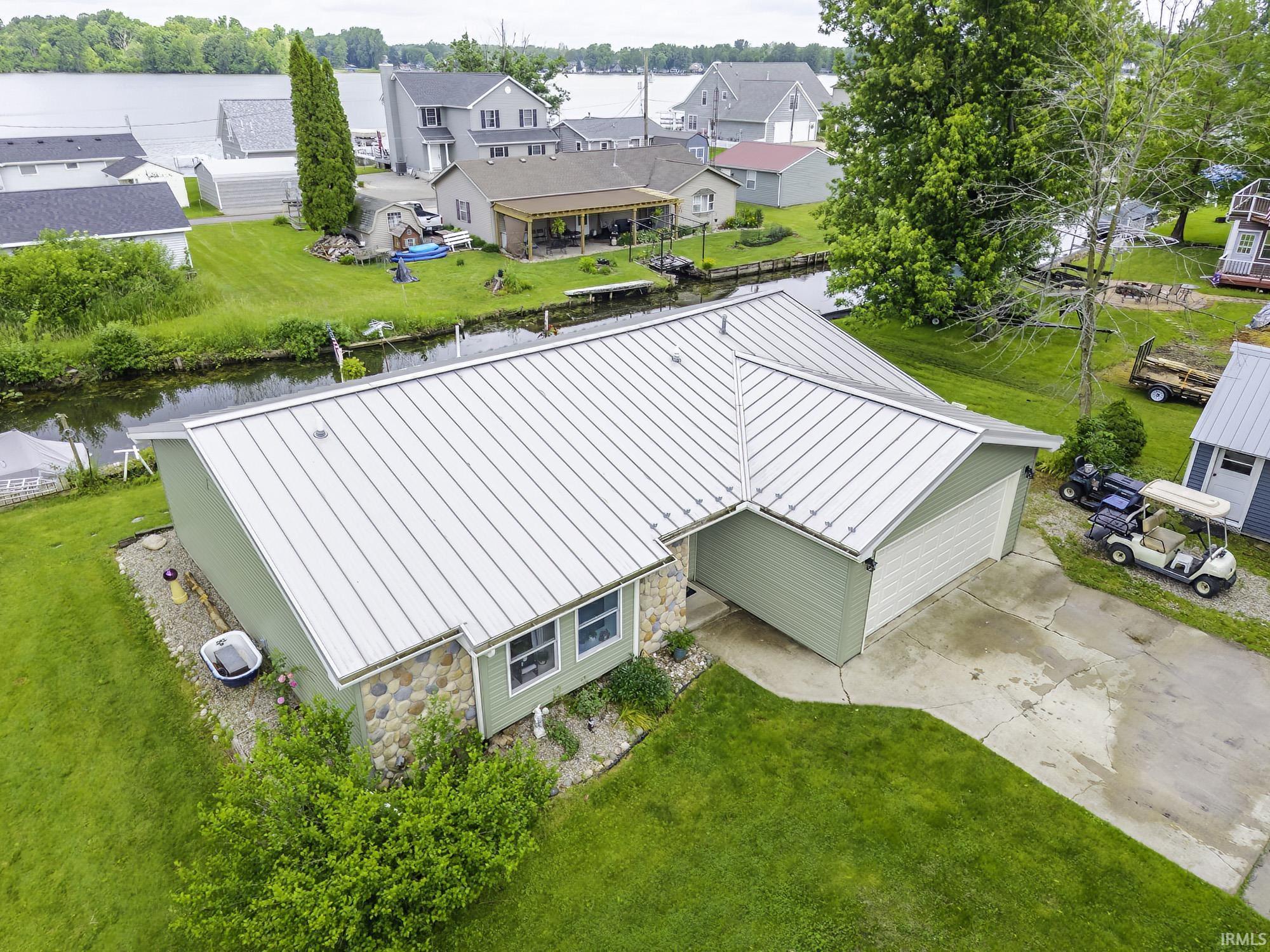 Image 2: Single-story residence featuring a durable metal roof and an attached two-car garage, Aerial View