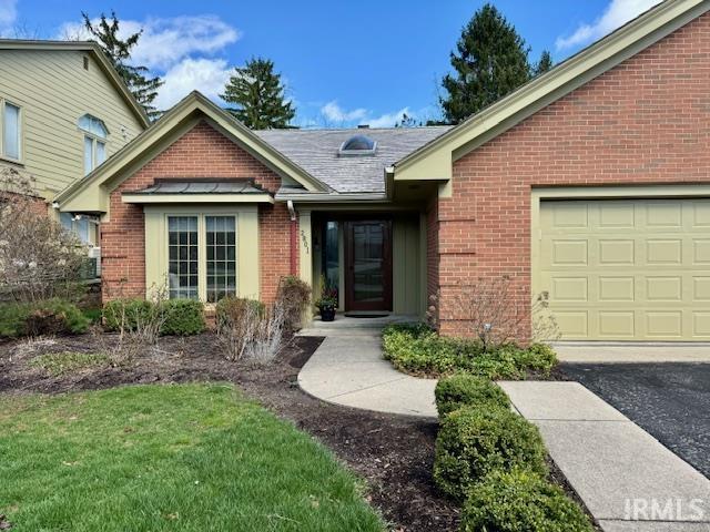 Image 2: Entrance to property with brick siding, a garage, and a yard, Entry Image 2: Entrance to property with brick siding, a garage, and a yard, Entry