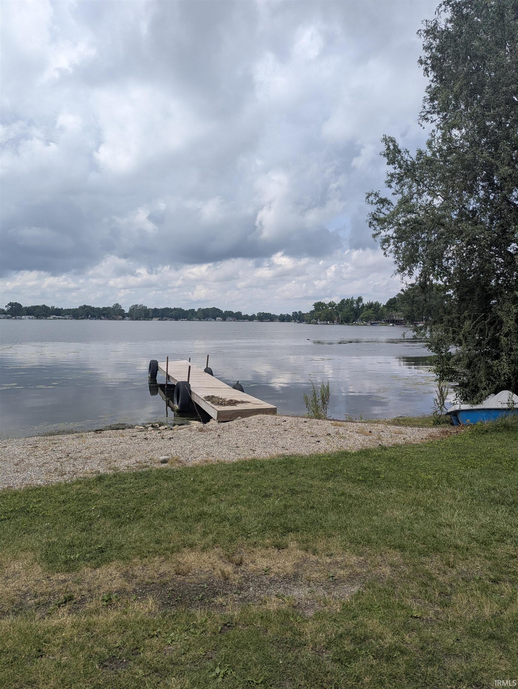 Image 2: Waterfront property featuring a private dock, gravel shoreline, and mature trees, Dock