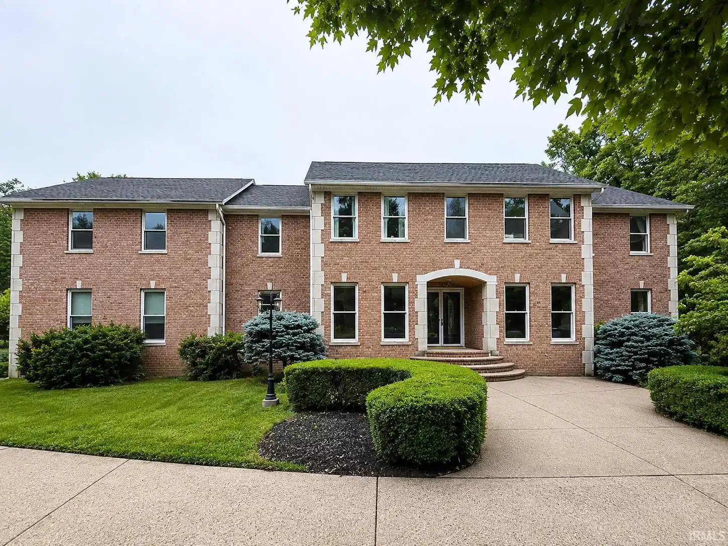Image 0: Brick facade residence featuring stone accents, a multi-pane front entry, and a paved circular drive, Front Of Structure Image 0: Brick facade residence featuring stone accents, a multi-pane front entry, and a paved circular drive, Front Of Structure