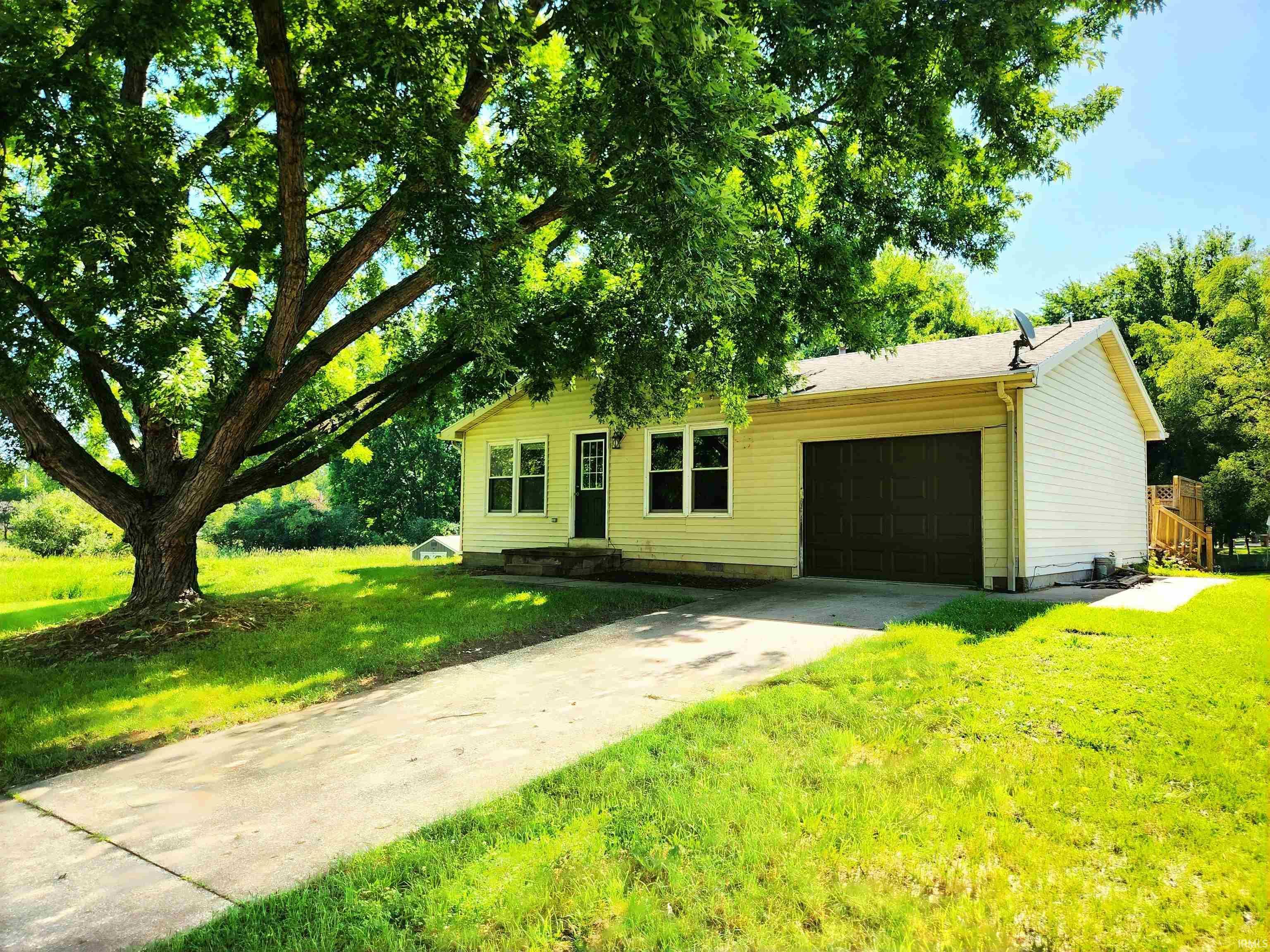 Image 0: Light-colored siding exterior featuring a dark front door, white-framed windows, and an attached single-car garage with a dark door, Front Of Structure