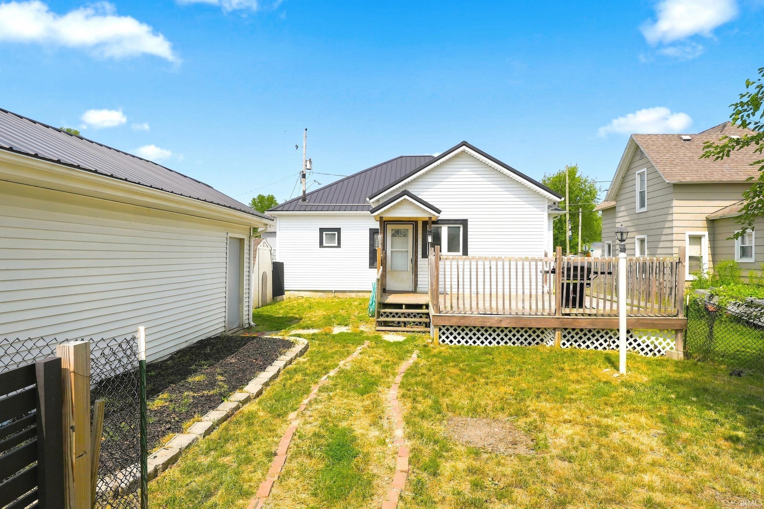 Image 1: Rear exterior featuring white siding and a metal roof, Back Of Structure Image 1: Rear exterior featuring white siding and a metal roof, Back Of Structure