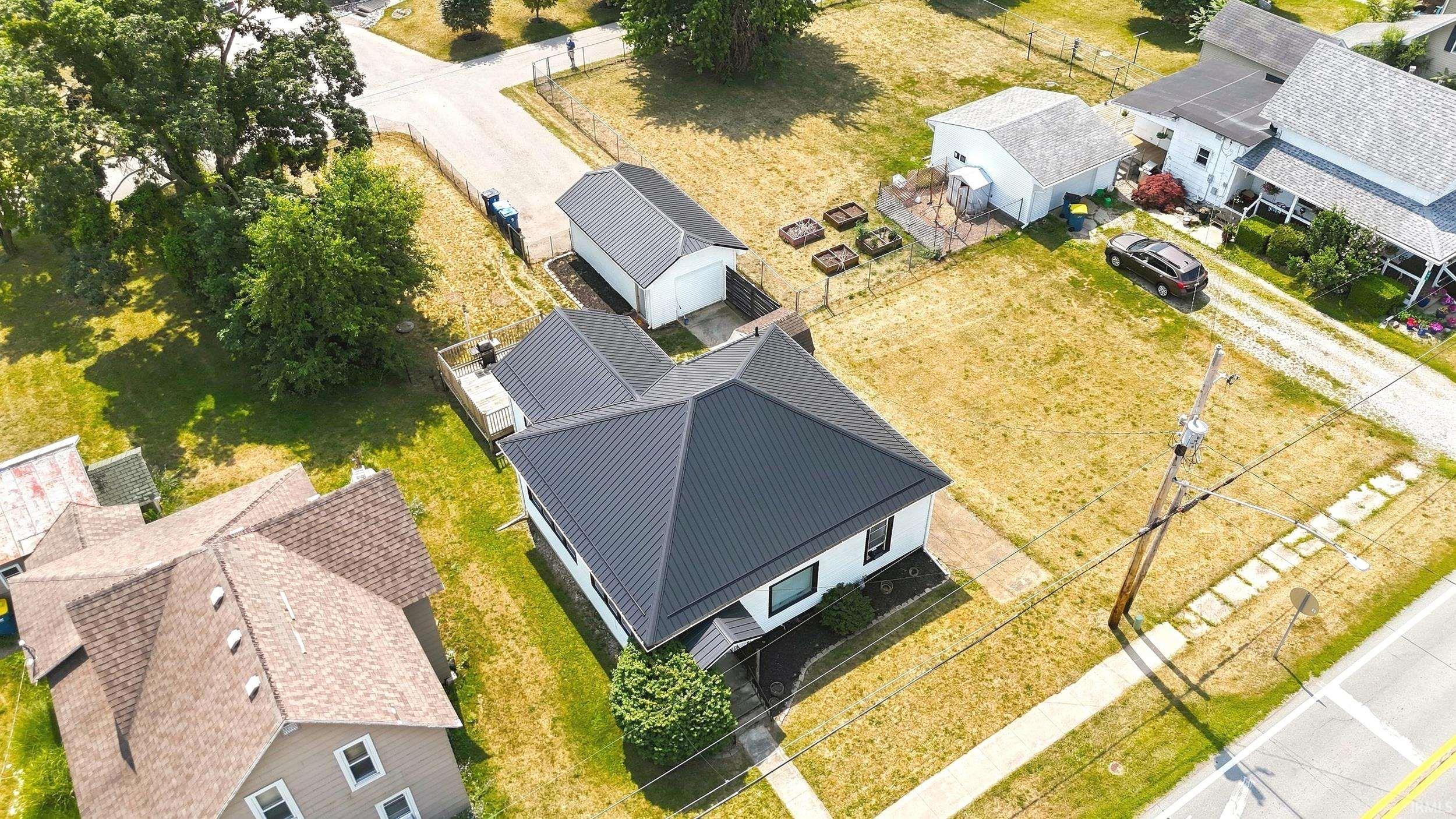 Image 2: Single-story residence featuring a dark metal roof, white exterior siding, and dark trim, Aerial View Image 2: Single-story residence featuring a dark metal roof, white exterior siding, and dark trim, Aerial View