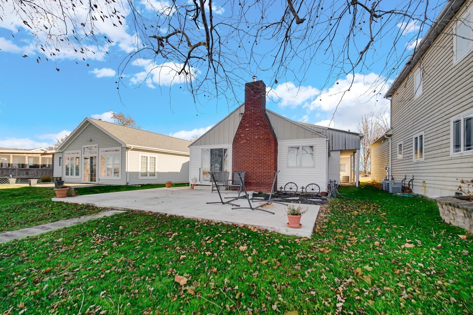 Image 3: Rear view of house featuring a yard, a patio area, a chimney, and board and batten siding, Back Of Structure
