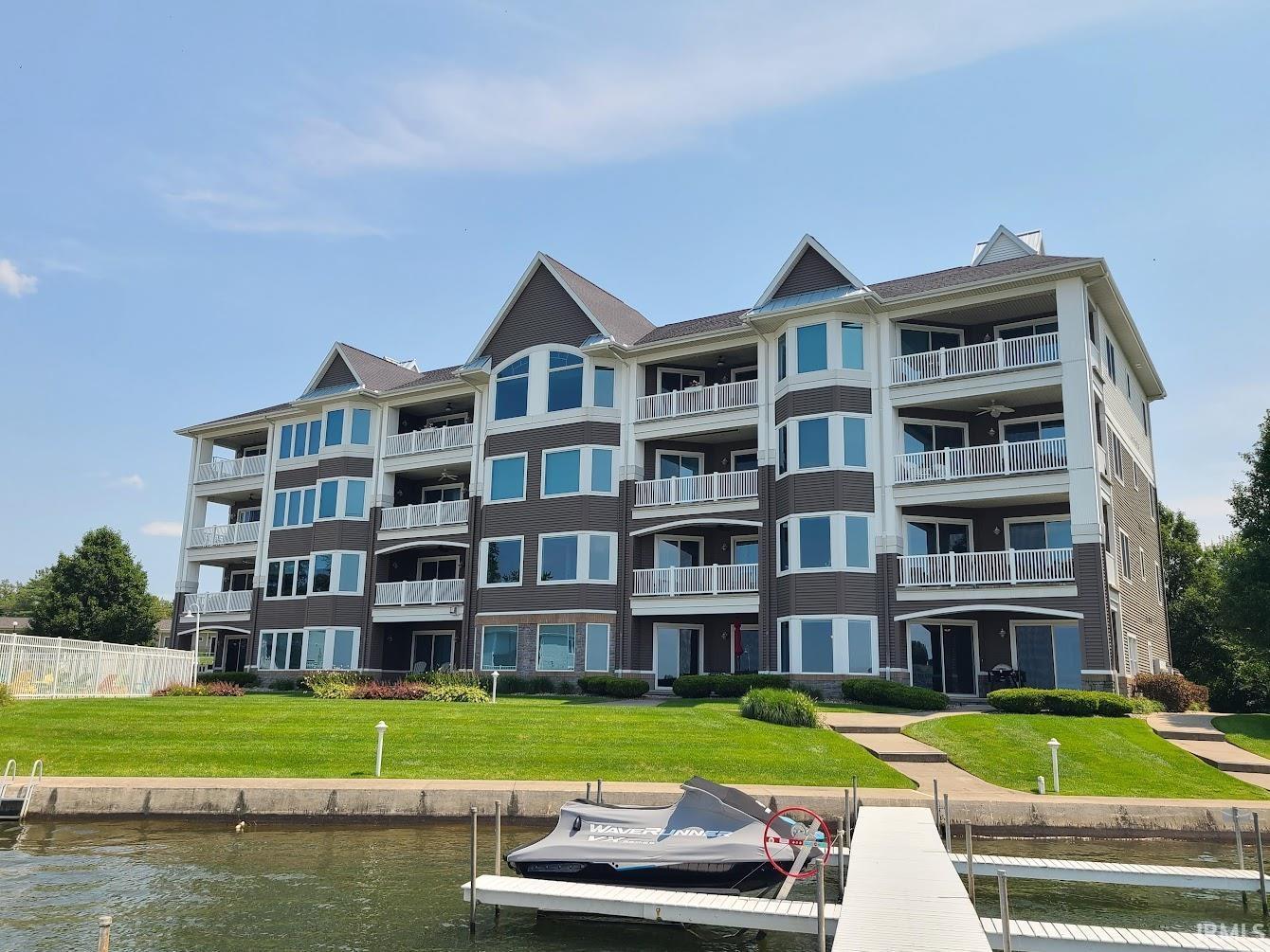 Image 2: Multi-level waterfront condominium building featuring private balconies, expansive windows, and a manicured lawn, Front Of Structure Image 2: Multi-level waterfront condominium building featuring private balconies, expansive windows, and a manicured lawn, Front Of Structure