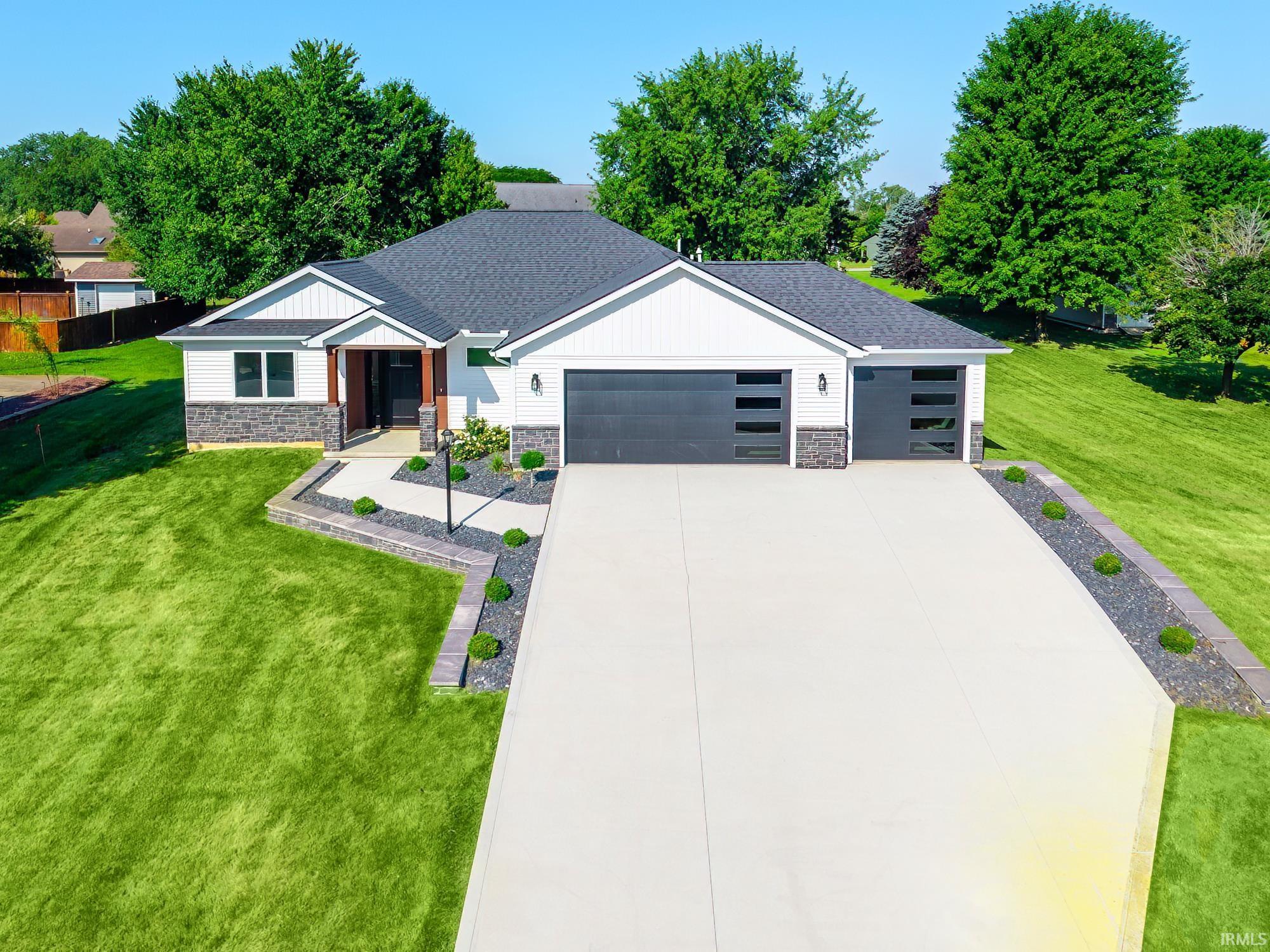 Image 2: Contemporary home exterior featuring white siding, dark gray stone accents, a dark shingle roof, and a concrete driveway, Front Of Structure Image 2: Contemporary home exterior featuring white siding, dark gray stone accents, a dark shingle roof, and a concrete driveway, Front Of Structure