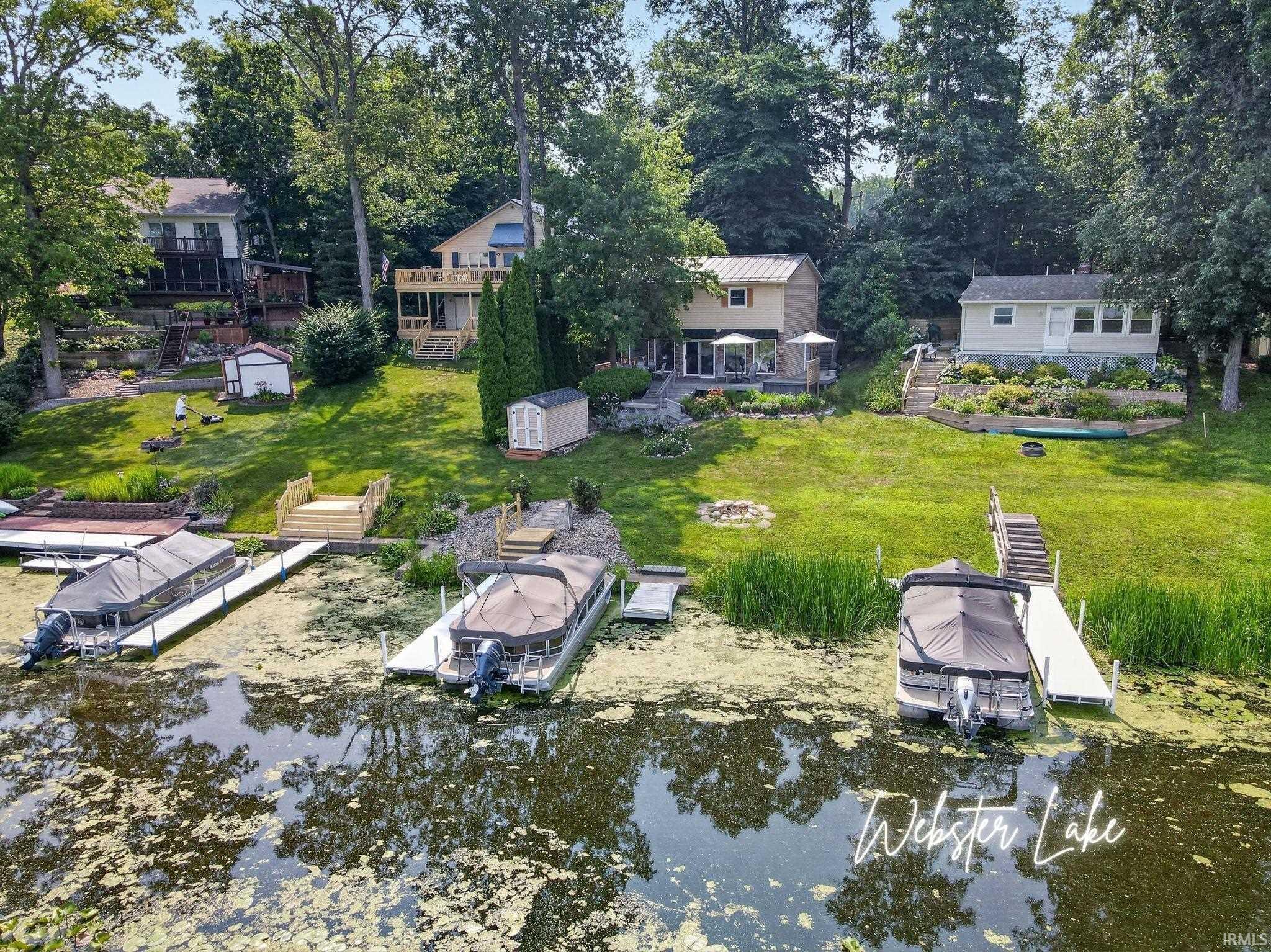 Image 0: Waterfront property featuring multiple docks, direct lake access, and a spacious lawn, Aerial View Image 0: Waterfront property featuring multiple docks, direct lake access, and a spacious lawn, Aerial View