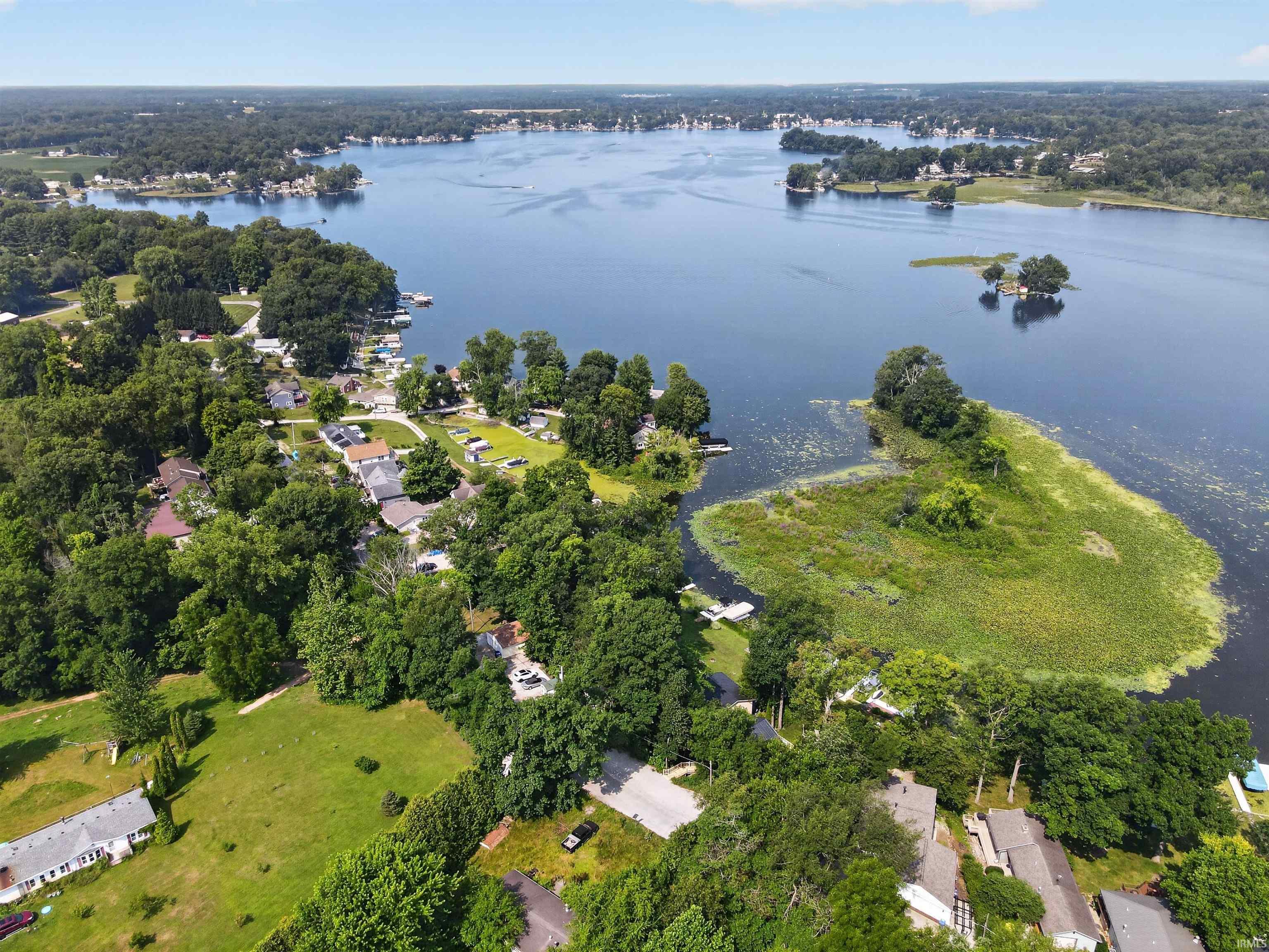 Image 3: Expansive lakefront setting featuring mature trees and established residences, Aerial View Image 3: Expansive lakefront setting featuring mature trees and established residences, Aerial View