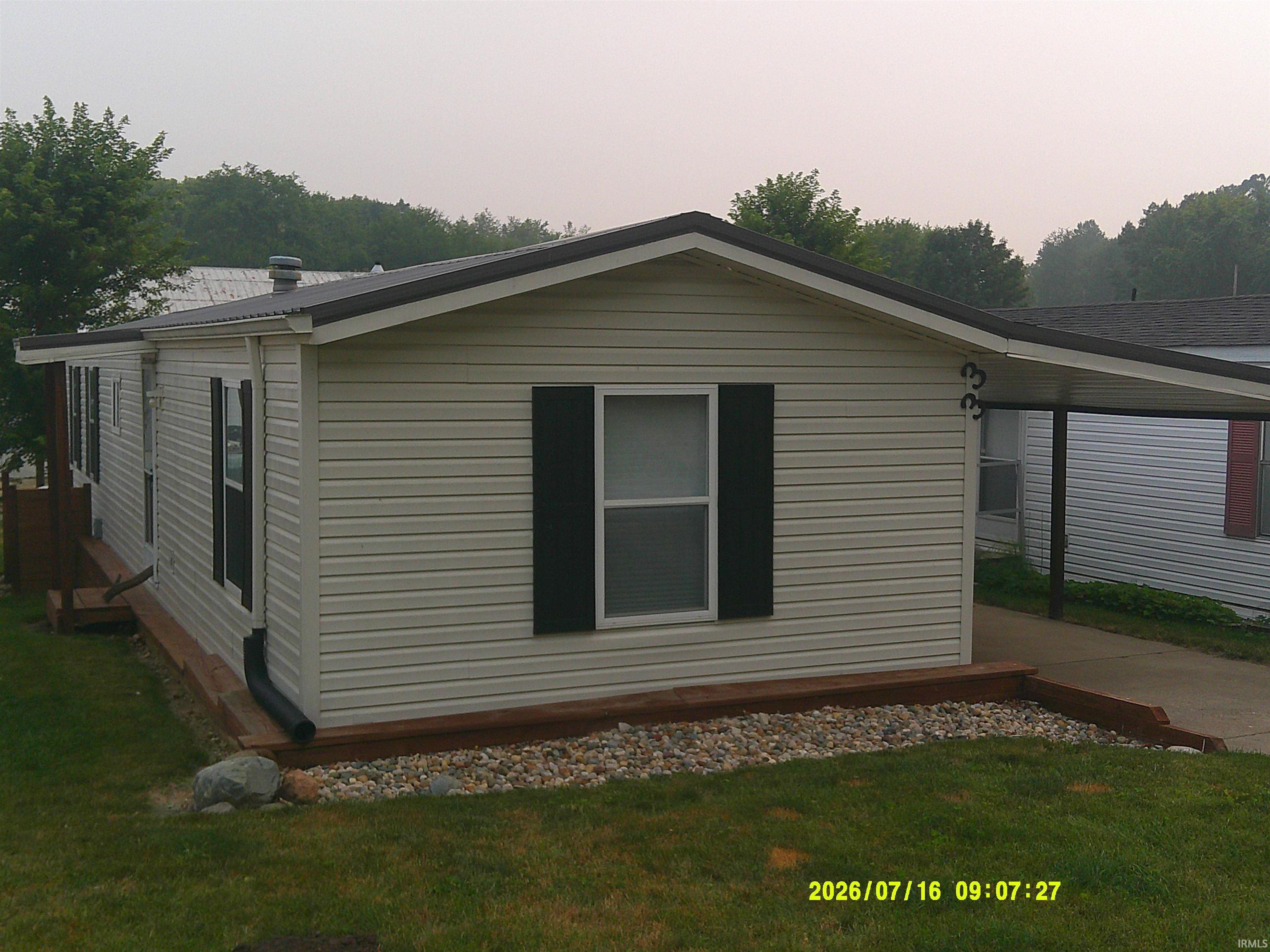 Image 2: Cream-colored siding with black window shutters and a dark roof, Side Of Structure Image 2: Cream-colored siding with black window shutters and a dark roof, Side Of Structure