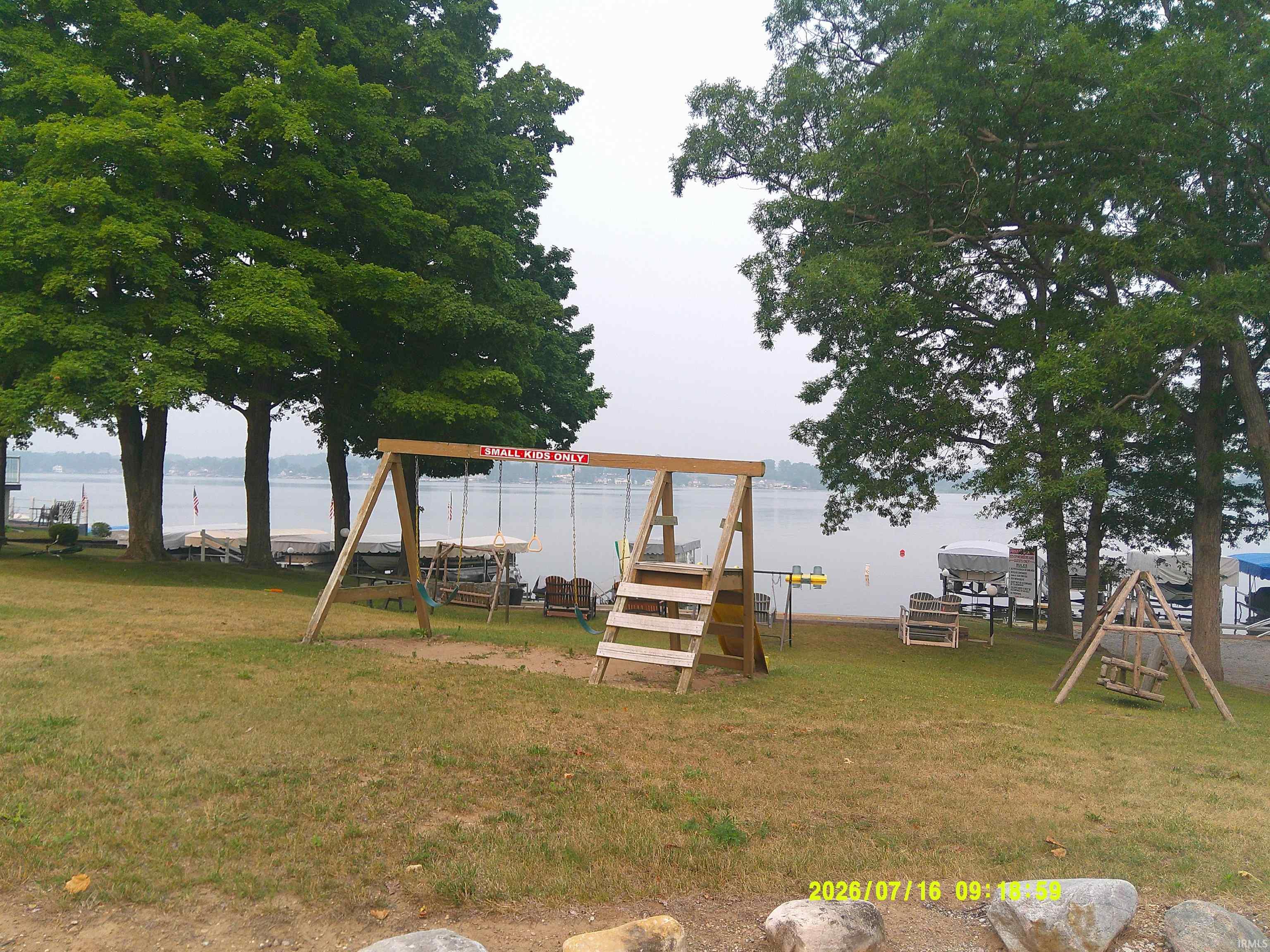 Image 3: Lakeside property featuring mature trees and a manicured lawn leading to the water's edge, Playground Image 3: Lakeside property featuring mature trees and a manicured lawn leading to the water's edge, Playground