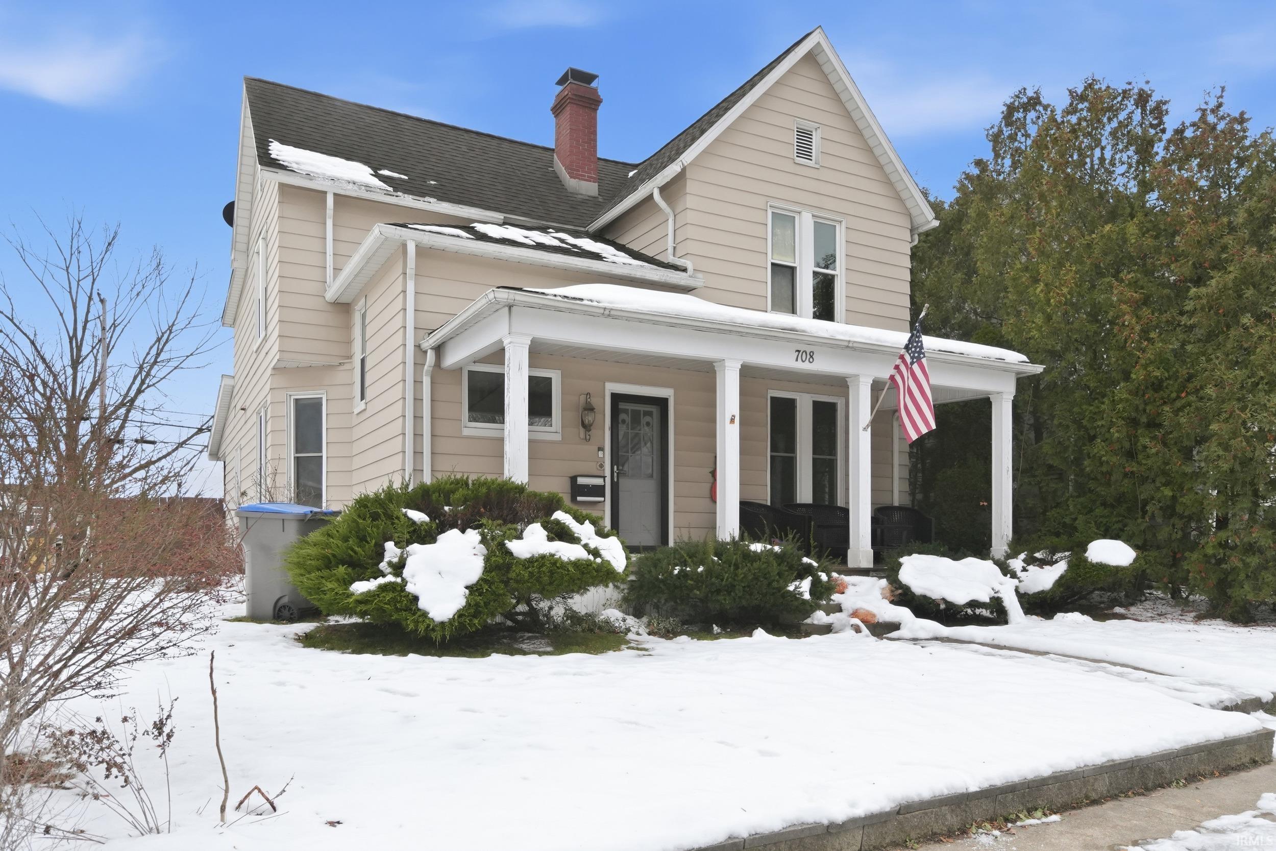 Image 1: View of front of property featuring a porch, a shingled roof, and a chimney, Front Of Structure