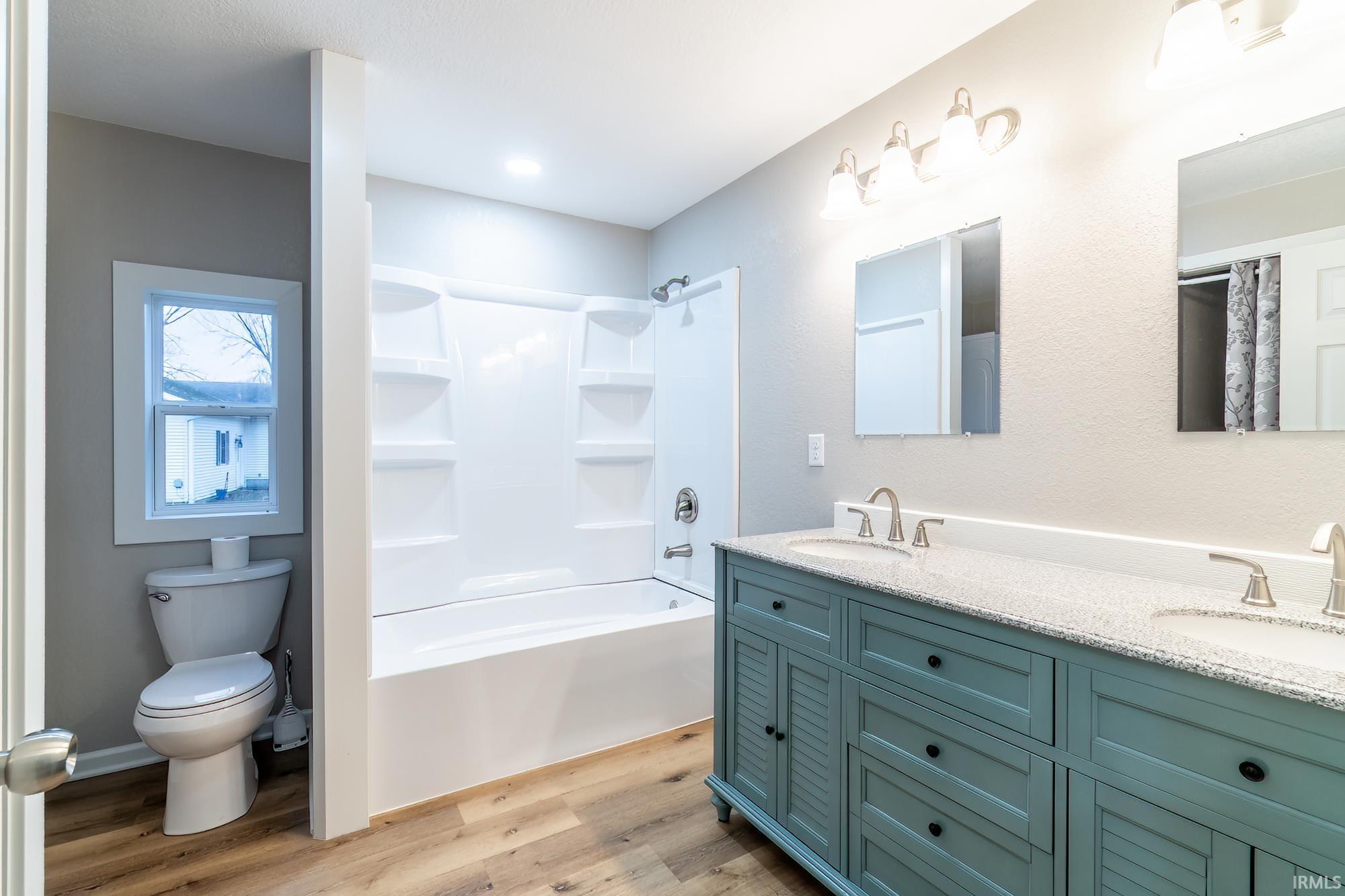 Image 3: Full bath with double vanity, light wood-style floors, and bathtub / shower combination, Bathroom Image 3: Full bath with double vanity, light wood-style floors, and bathtub / shower combination, Bathroom