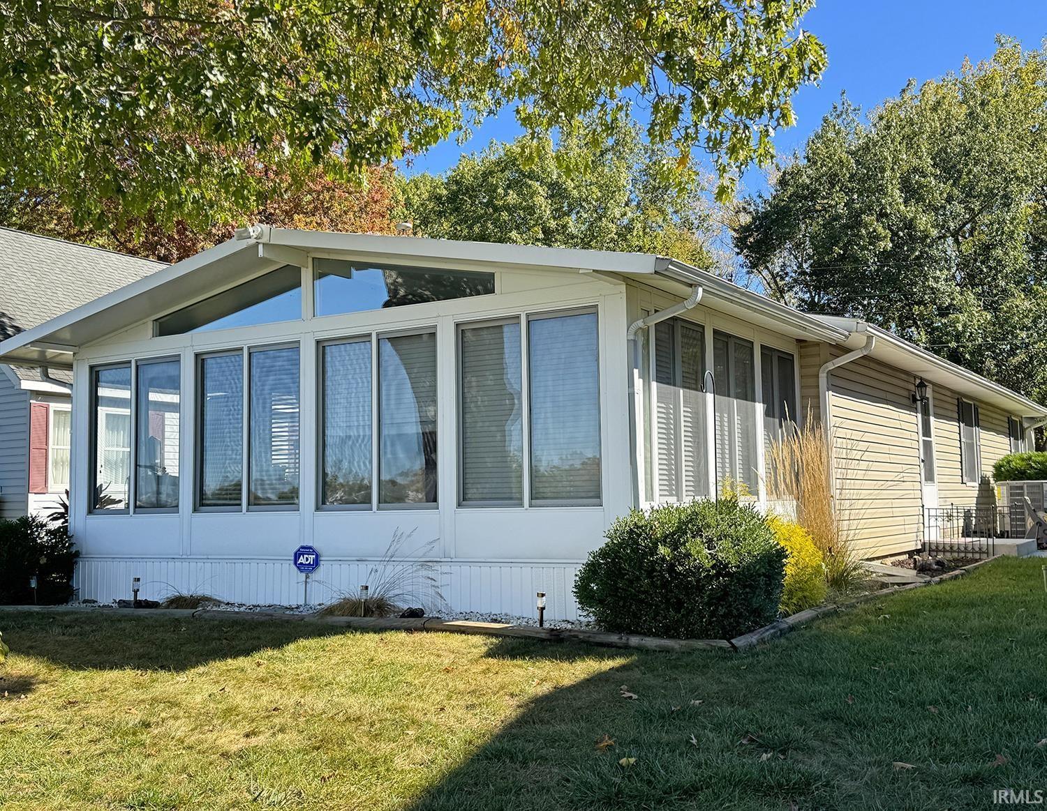 Image 0: View of side of home with a yard and a sunroom., Front Image 0: View of side of home with a yard and a sunroom., Front