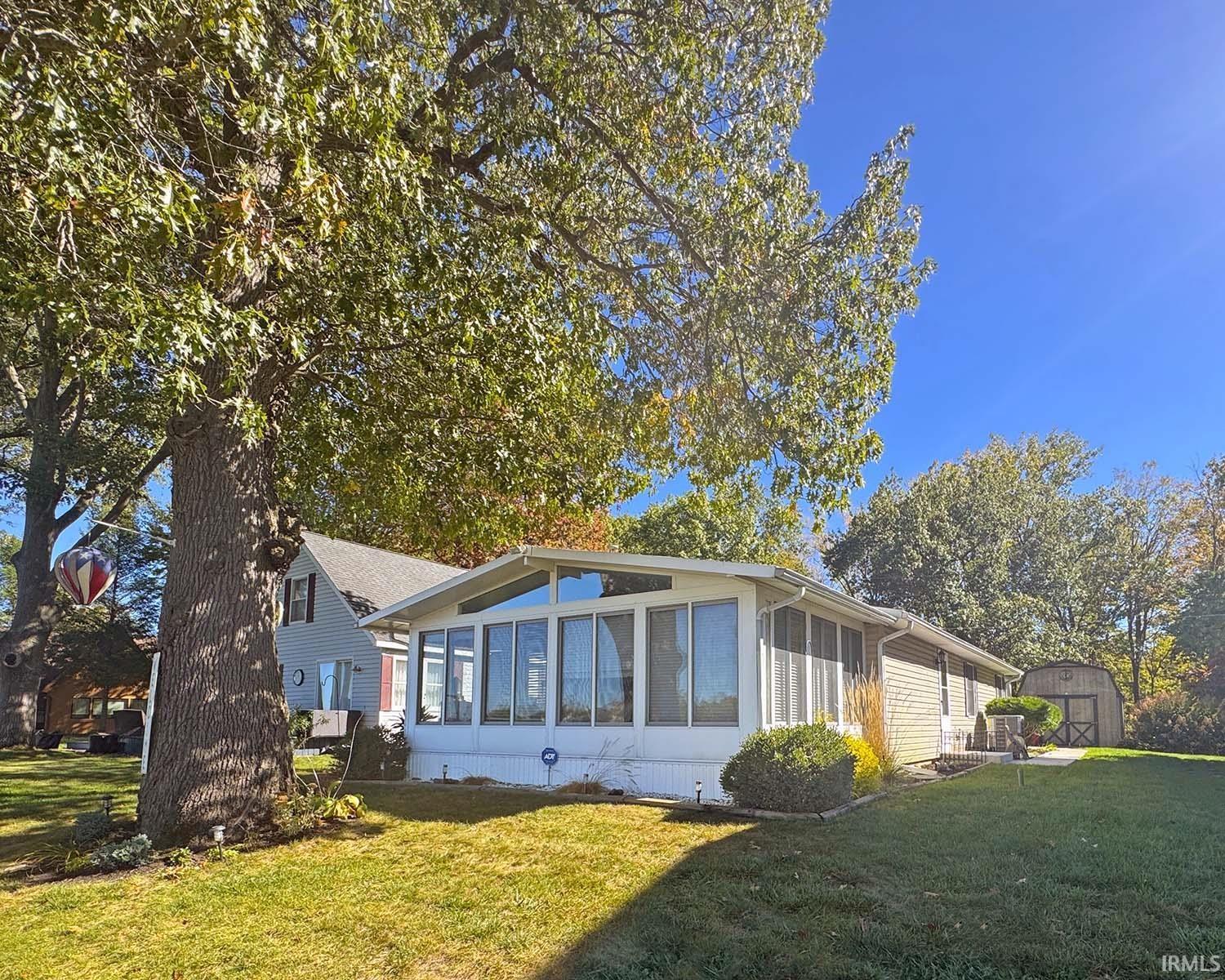 Image 1: Rear view of property featuring a sunroom, a lawn, and a shed., Front Image 1: Rear view of property featuring a sunroom, a lawn, and a shed., Front
