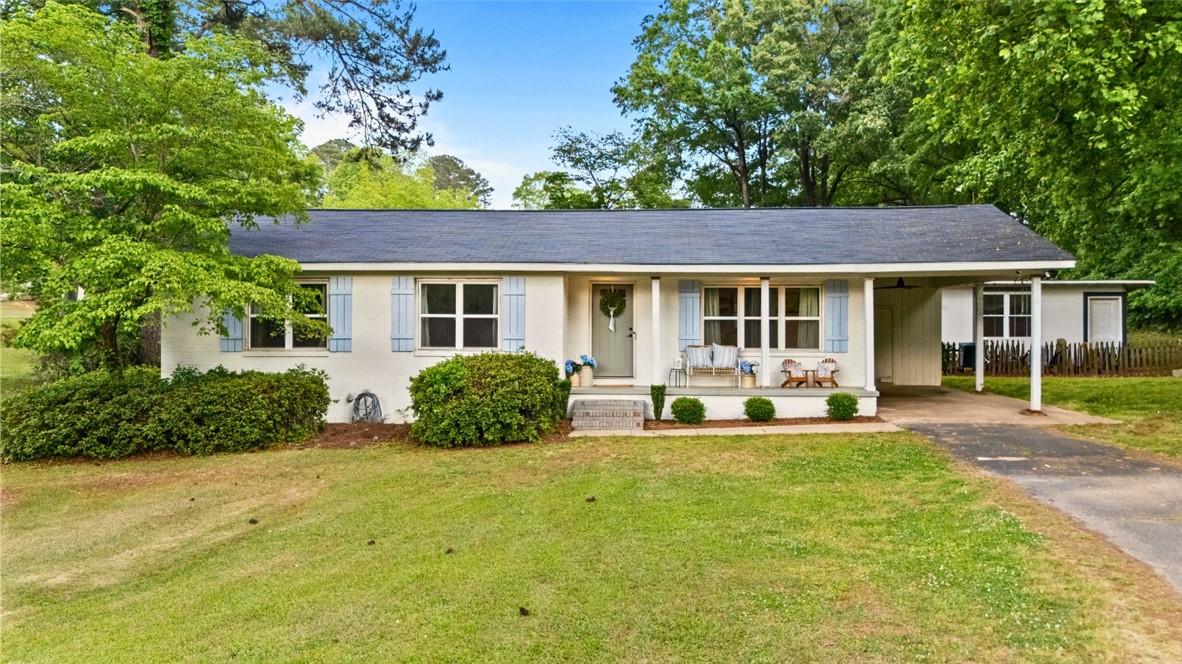 Image 1: This charming home offers a lovely front porch and