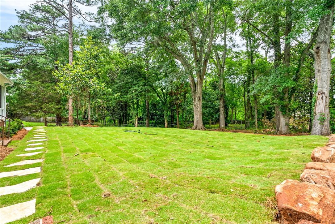 Image 4: A spacious backyard with mature trees and a neatly
