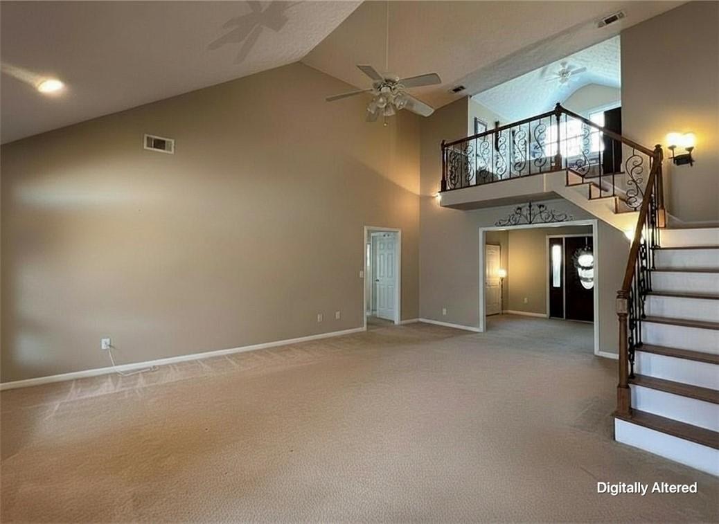 Image 3: A spacious living area features soaring vaulted ce