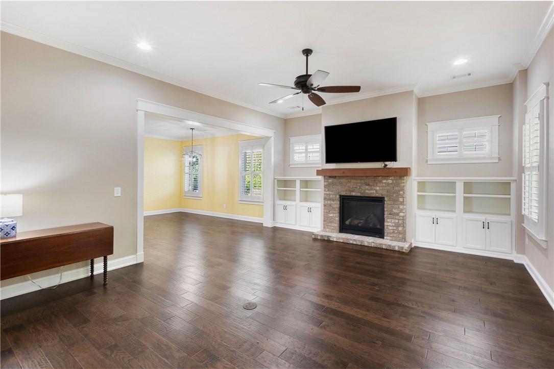 Image 4: Wood floors and a brick fireplace with built-in sh