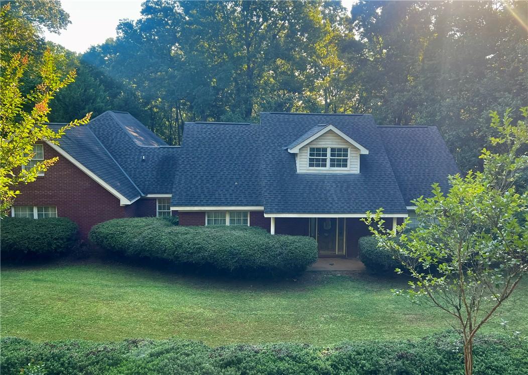 Image 1: Mature trees and lush shrubbery enhance this appea