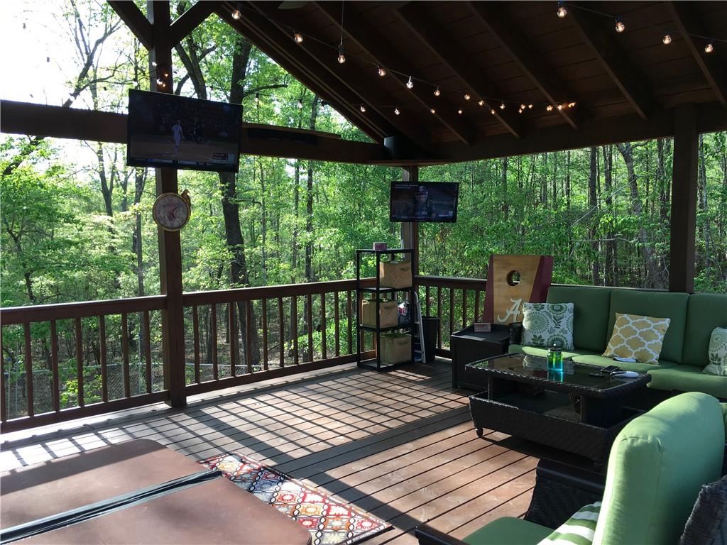 Image 3: An inviting covered deck offers forest views and a