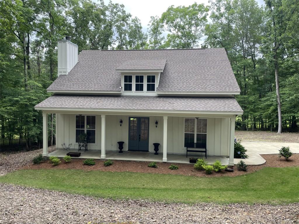 Image 1: A charming facade welcomes with a covered porch an