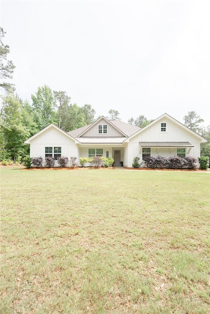 Image 2: A classic white home, framed by lush greenery, pre