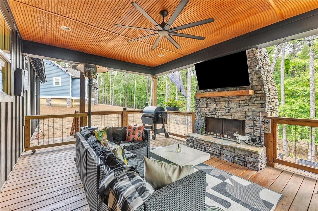 Image 2: A spacious covered porch features a stone fireplac