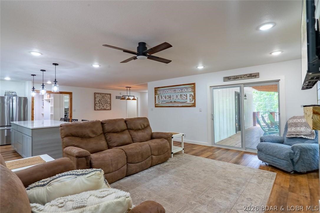 Image 3: Living room has large windows & door to covered de