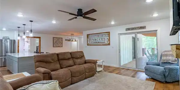 Image 3: Living room has large windows & door to covered de