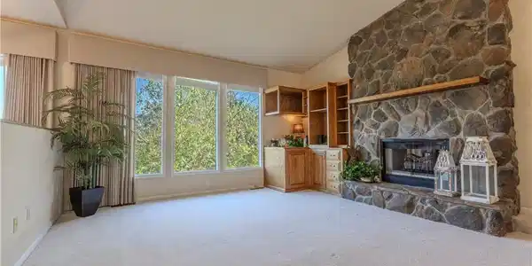 Image 4: Big windows with a cozy stone fireplace in a sunke